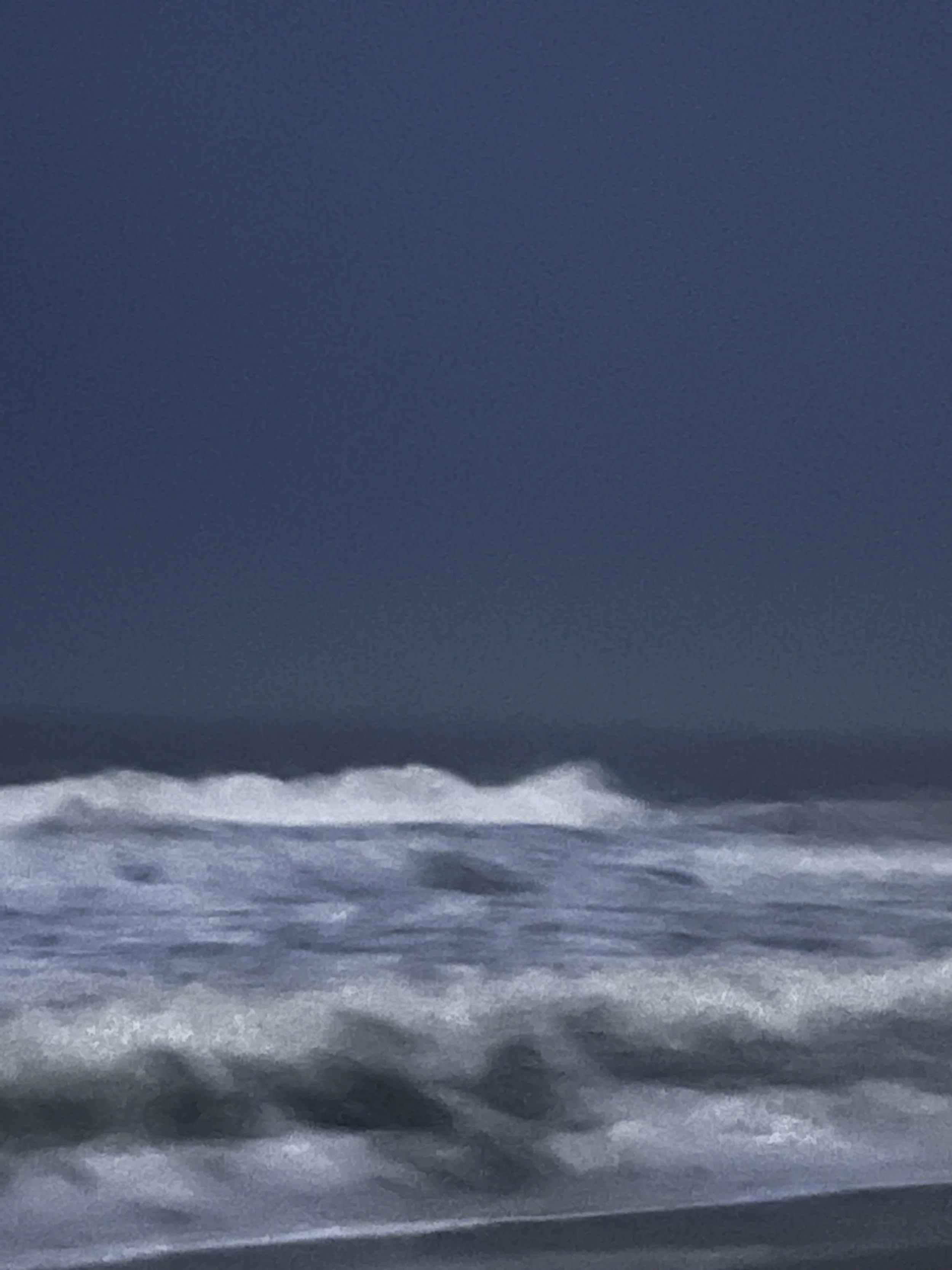 At the Edge of Light, Fire Island. Blue-grey sky over churning foam close to the shoreline.