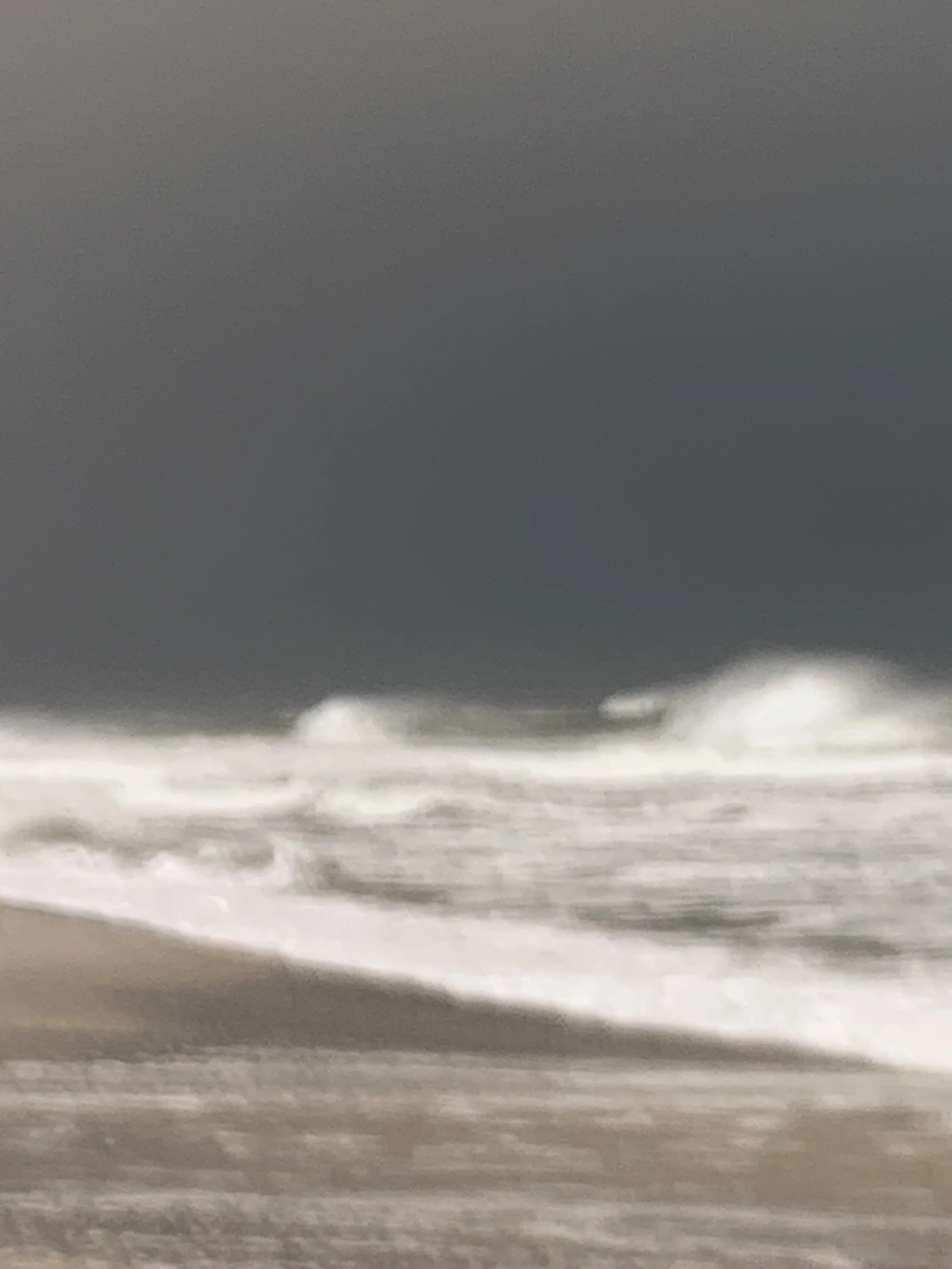 At the Edge of Light, Fire Island. Heavy grey sky over white surf breaking on an empty shore.