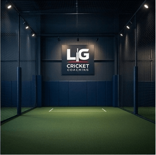 Indoor cricket practice net with a lit LIG Cricket Coaching sign on the back wall.