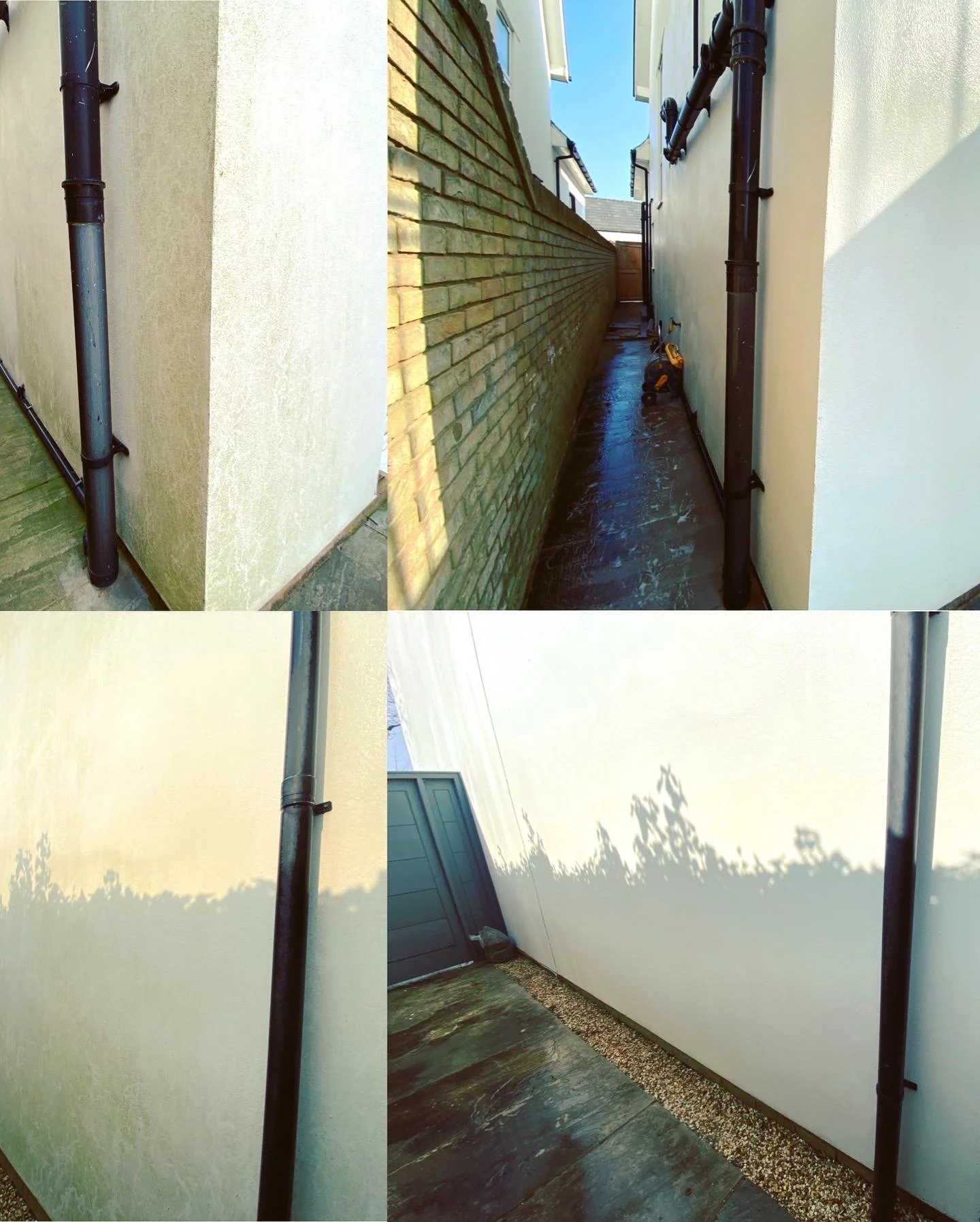 Side alley between two houses, one with a brick wall and the other with a smooth light-colored wall, wet ground, black drainpipes along the walls, a closed door at the end, and shadows of trees cast on the walls.
