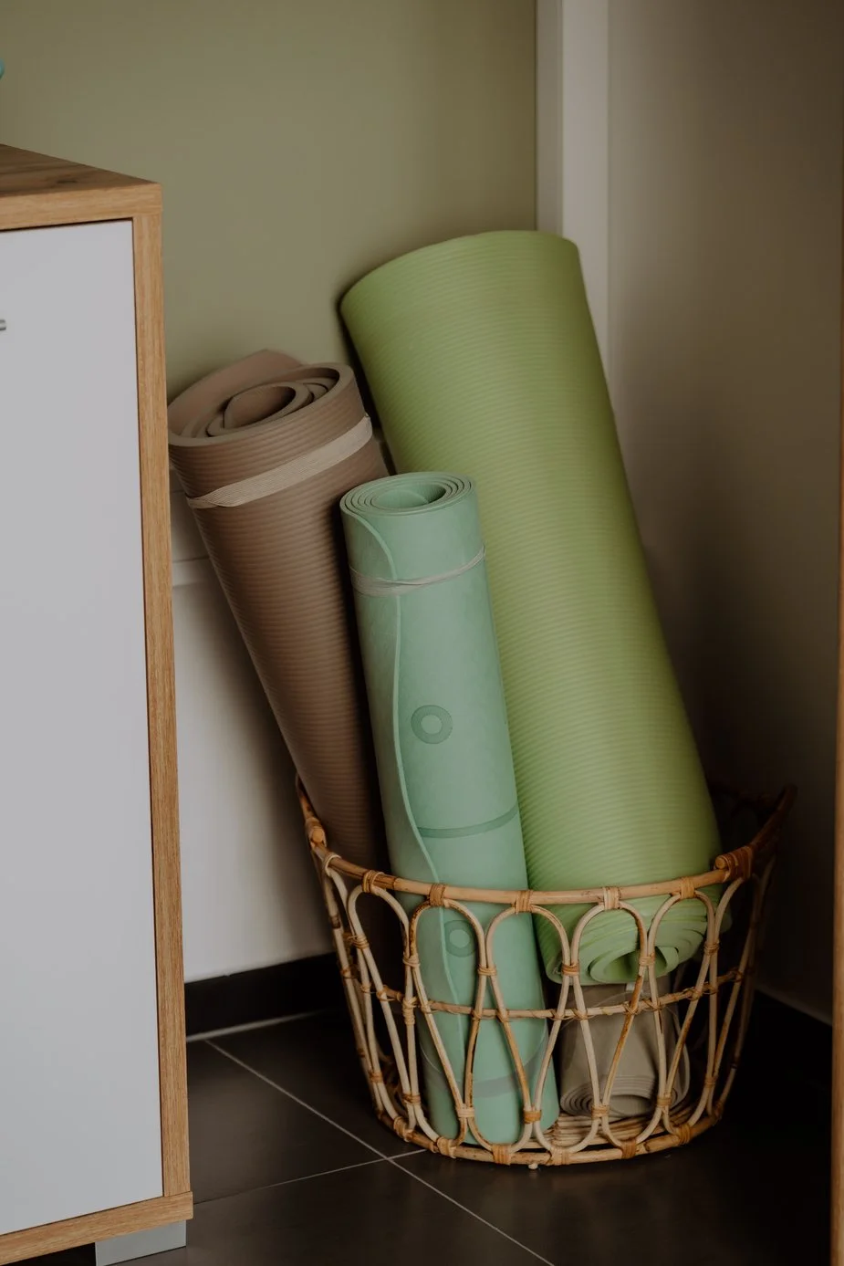 Mehrere aufgerollte Yogamatten in einem Korb für Übungen in der Physiotherapie