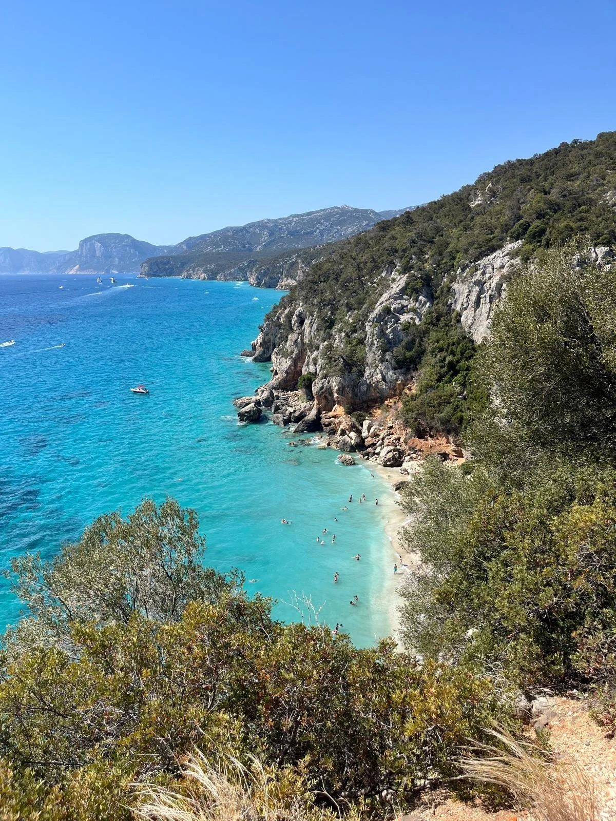 Een cala van Sardinie met helderblauw water met hoge kliffen en rotsen in de westkust.