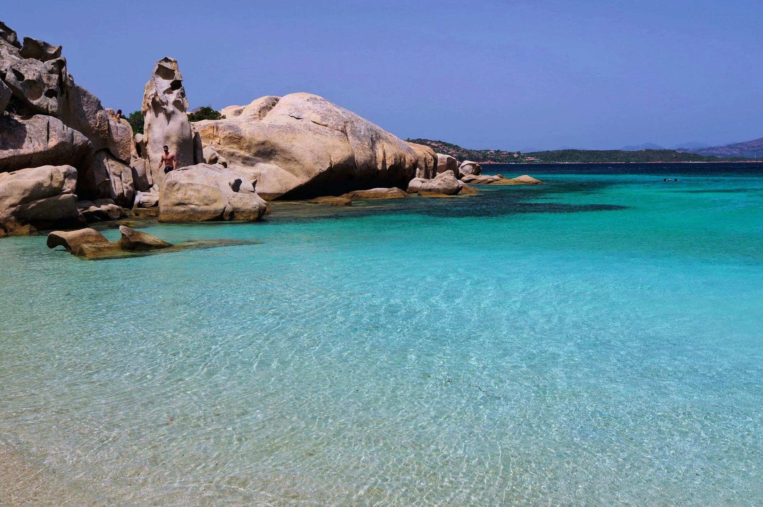 Vol in de zomer op Sardinie. Helderblauw water met grootte rotsen.