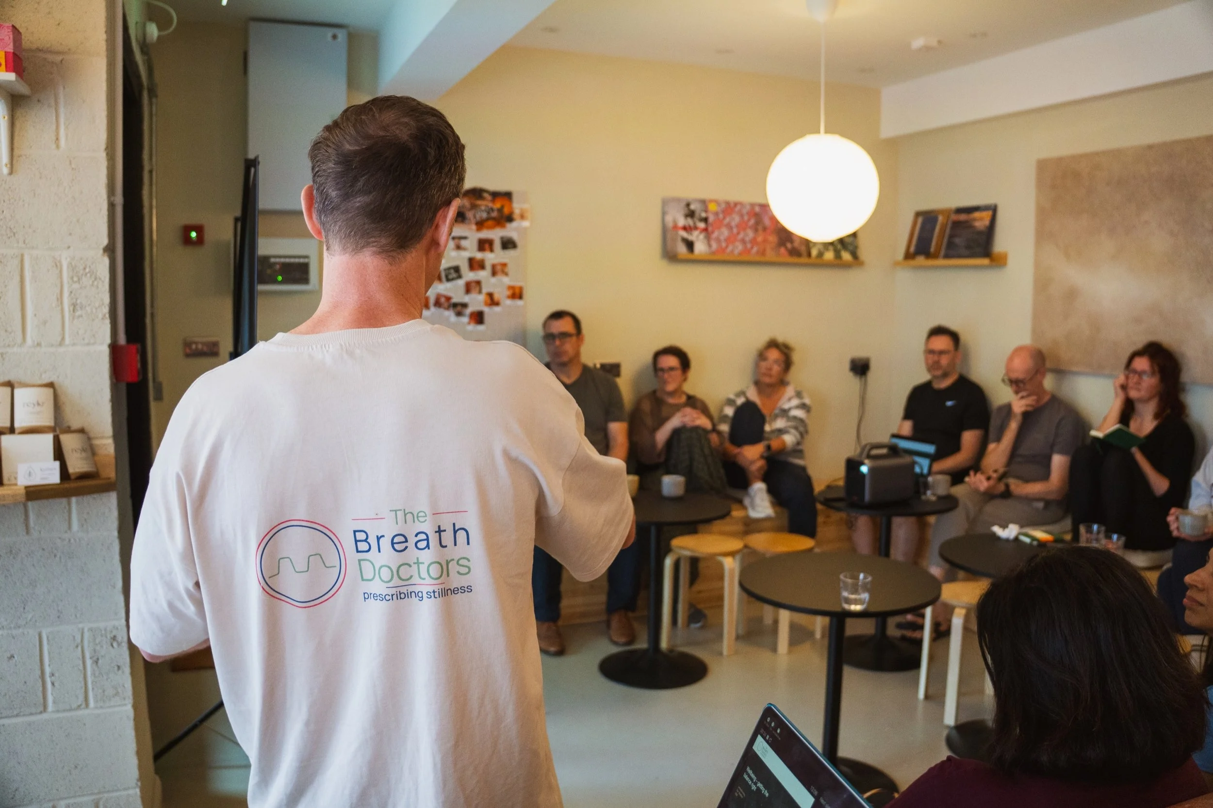 Dr James Brunning teaching a bespoke programme, seen from behind with The Breath Doctors logo