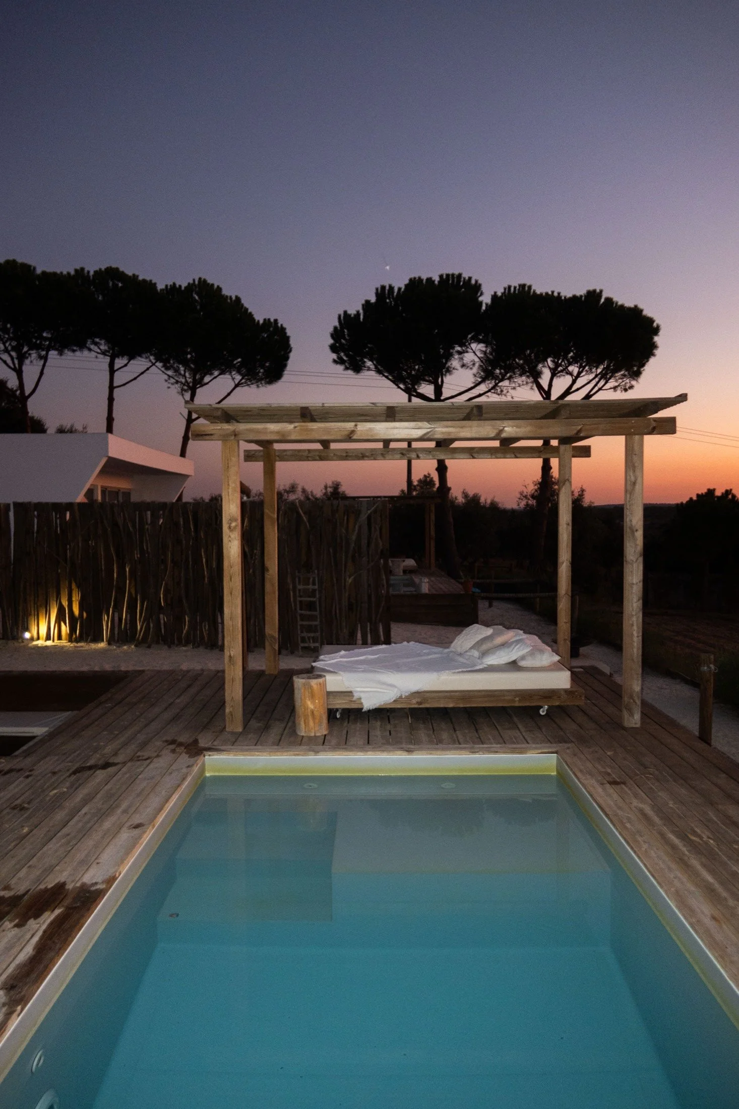 Daybed over the pool at dusk