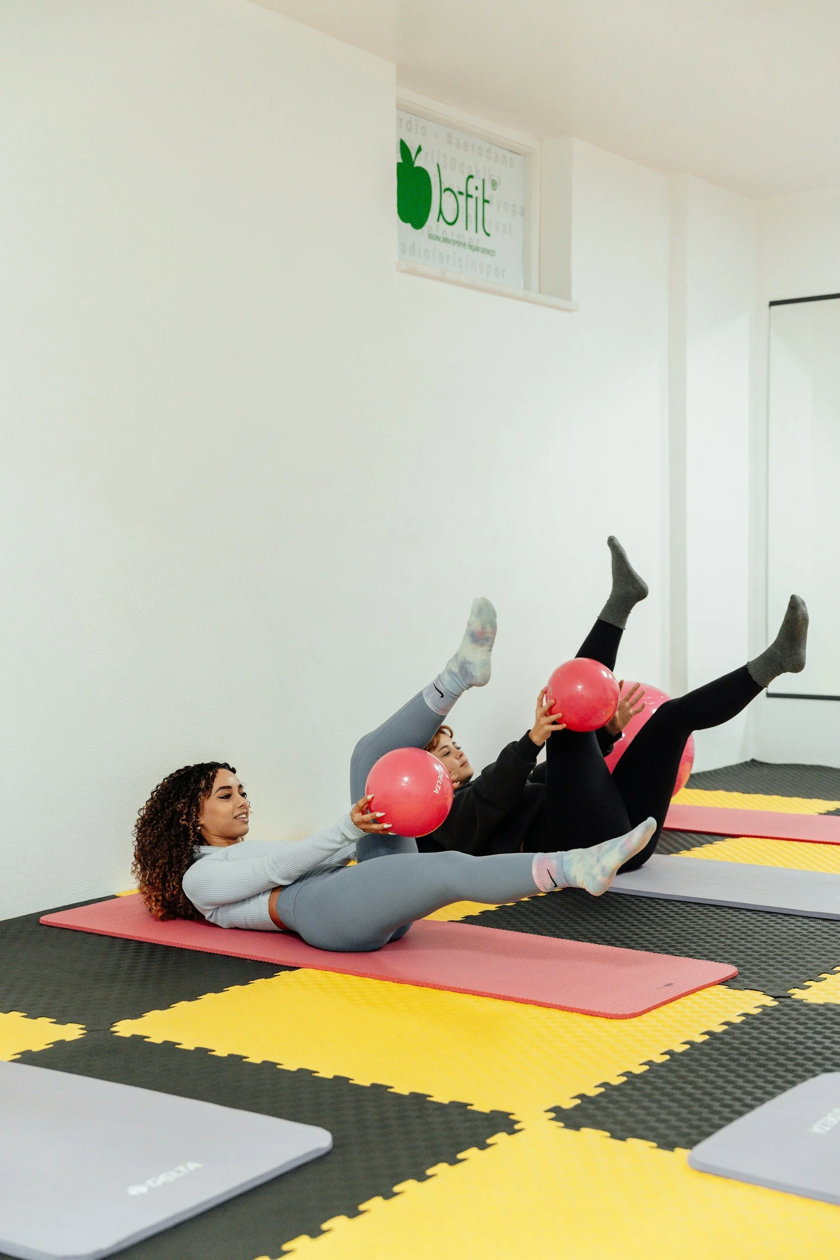 Group enjoying a Mat Pilates class using small exercise balls