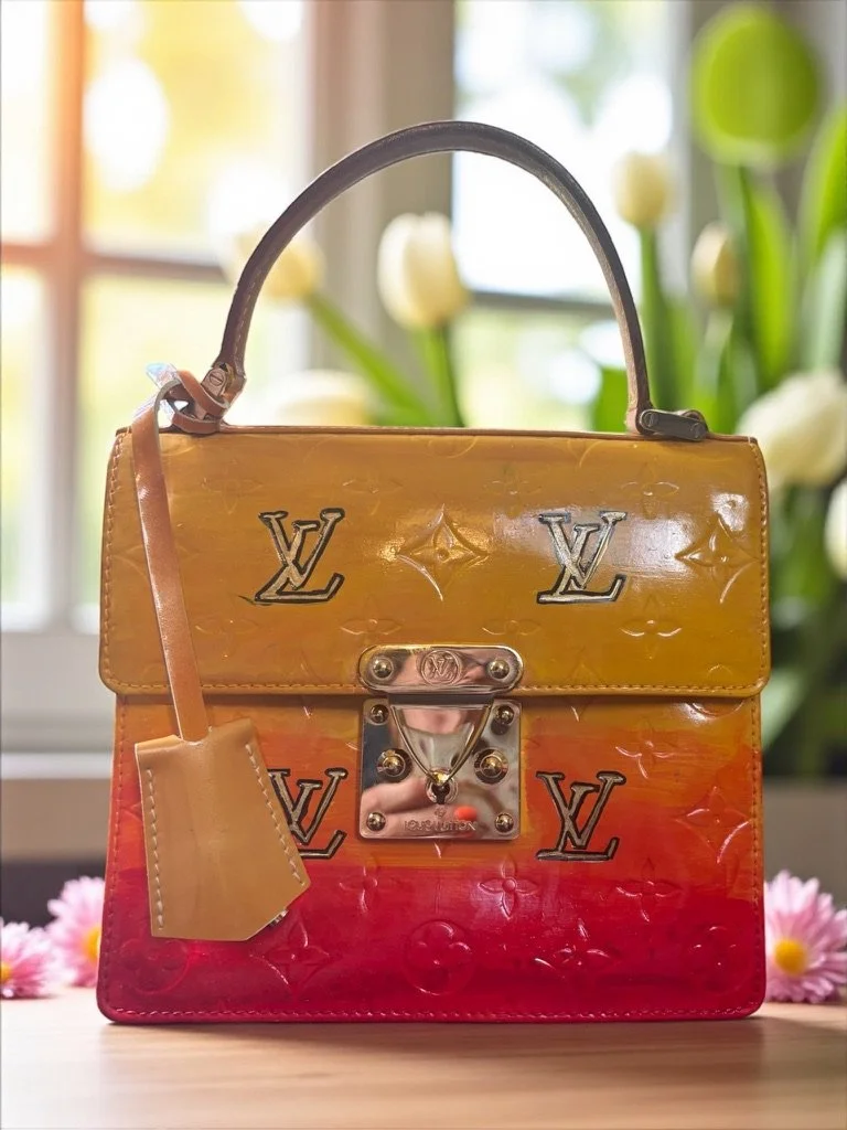The Transformation:

Rather than trying to disguise its age, I gave this vintage classic a bold new personality with a custom sunset ombré design in warm shades of golden yellow, orange, and crimson. The hand-painted Louis Vuitton monograms add a pla