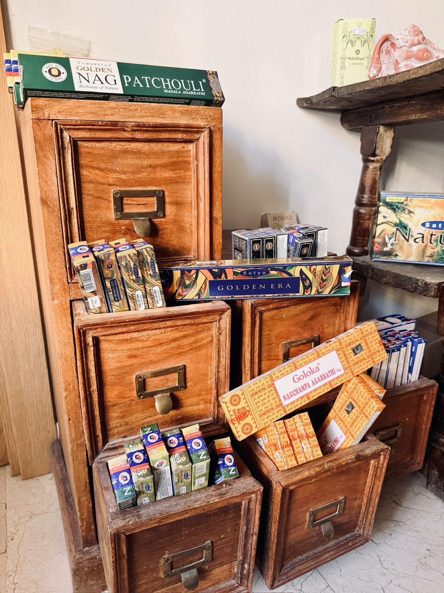 Estantería de madera antigua con varias cajas y paquetes de inciensos, salvia, palo santo, en guadalajara España.