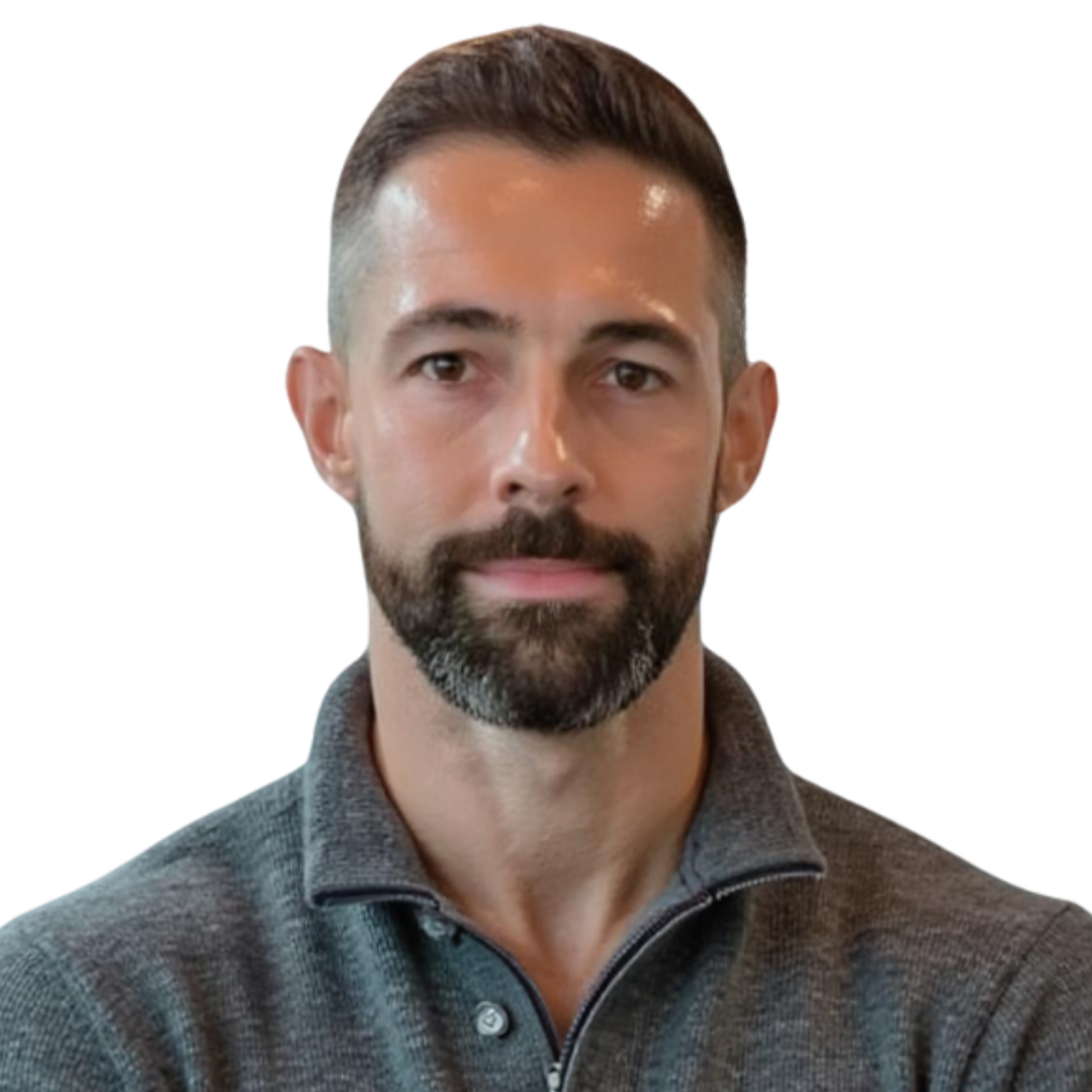 A man with short brown hair and a beard, wearing a dark gray zip-up sweater, facing forward with a neutral expression.