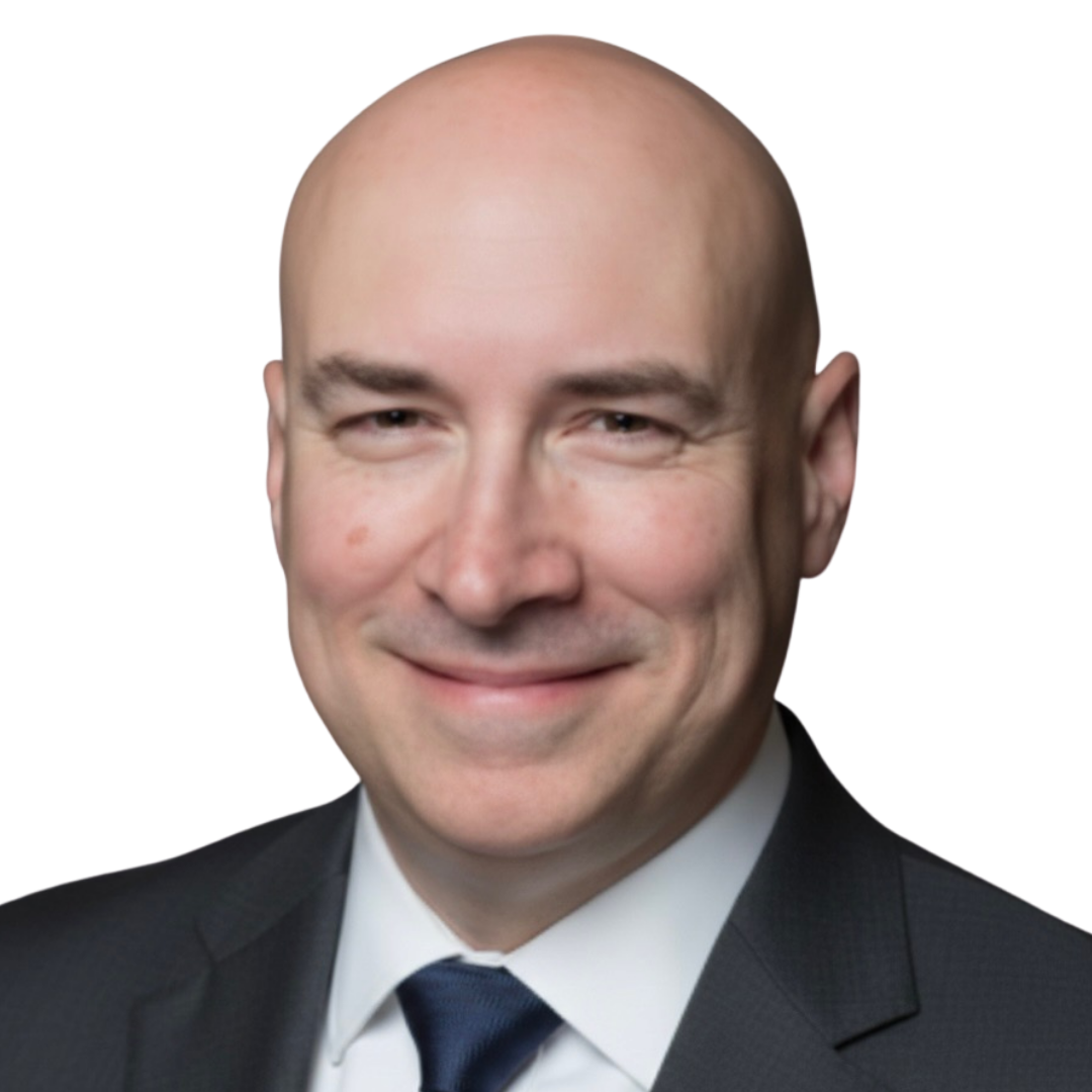 Headshot of a smiling bald man in a dark suit, white shirt, and dark tie.