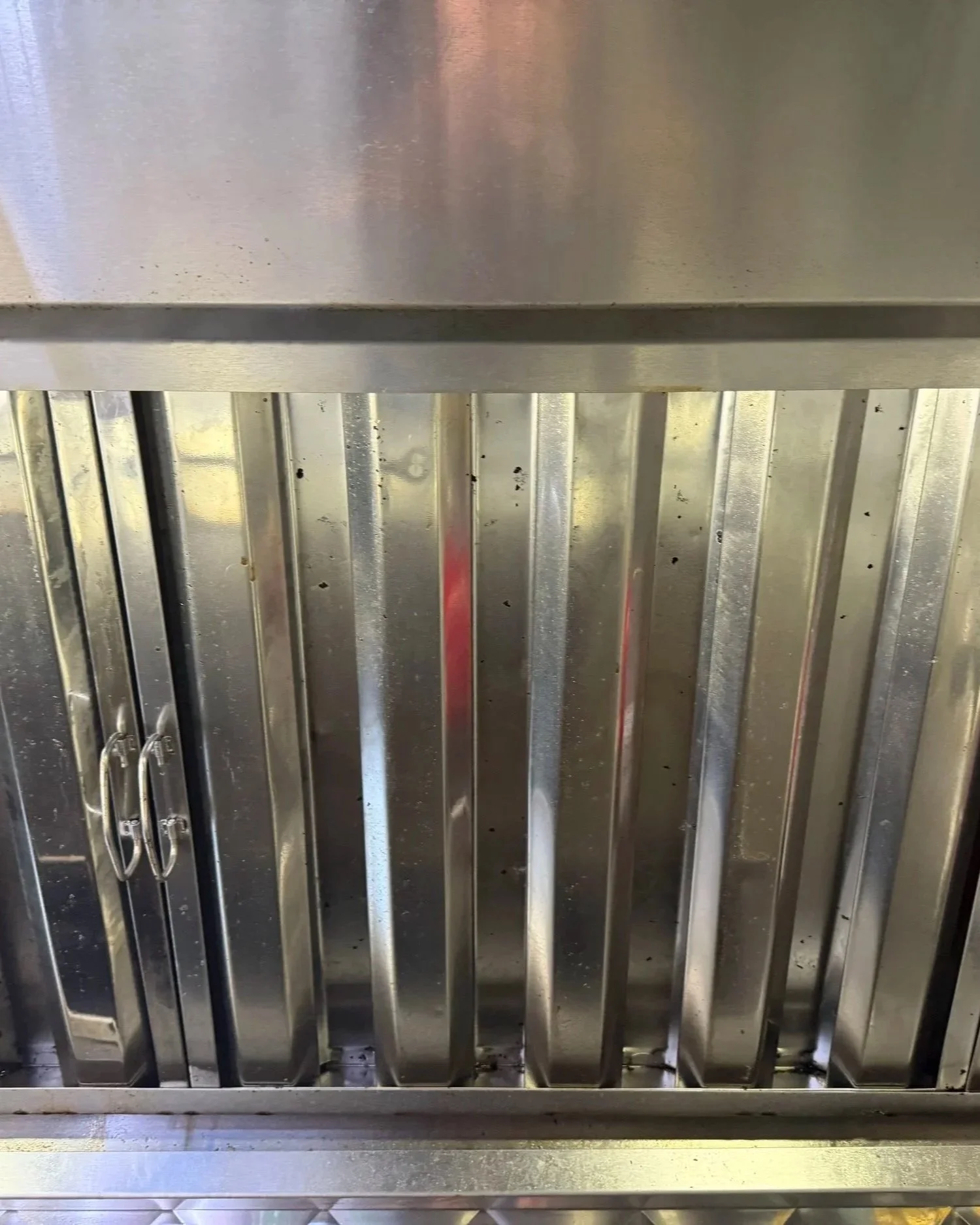 A metal cage or grill, possibly a storage or security enclosure, with several vertical bars and a horizontal panel at the top. The surface shows some signs of wear or dirt.