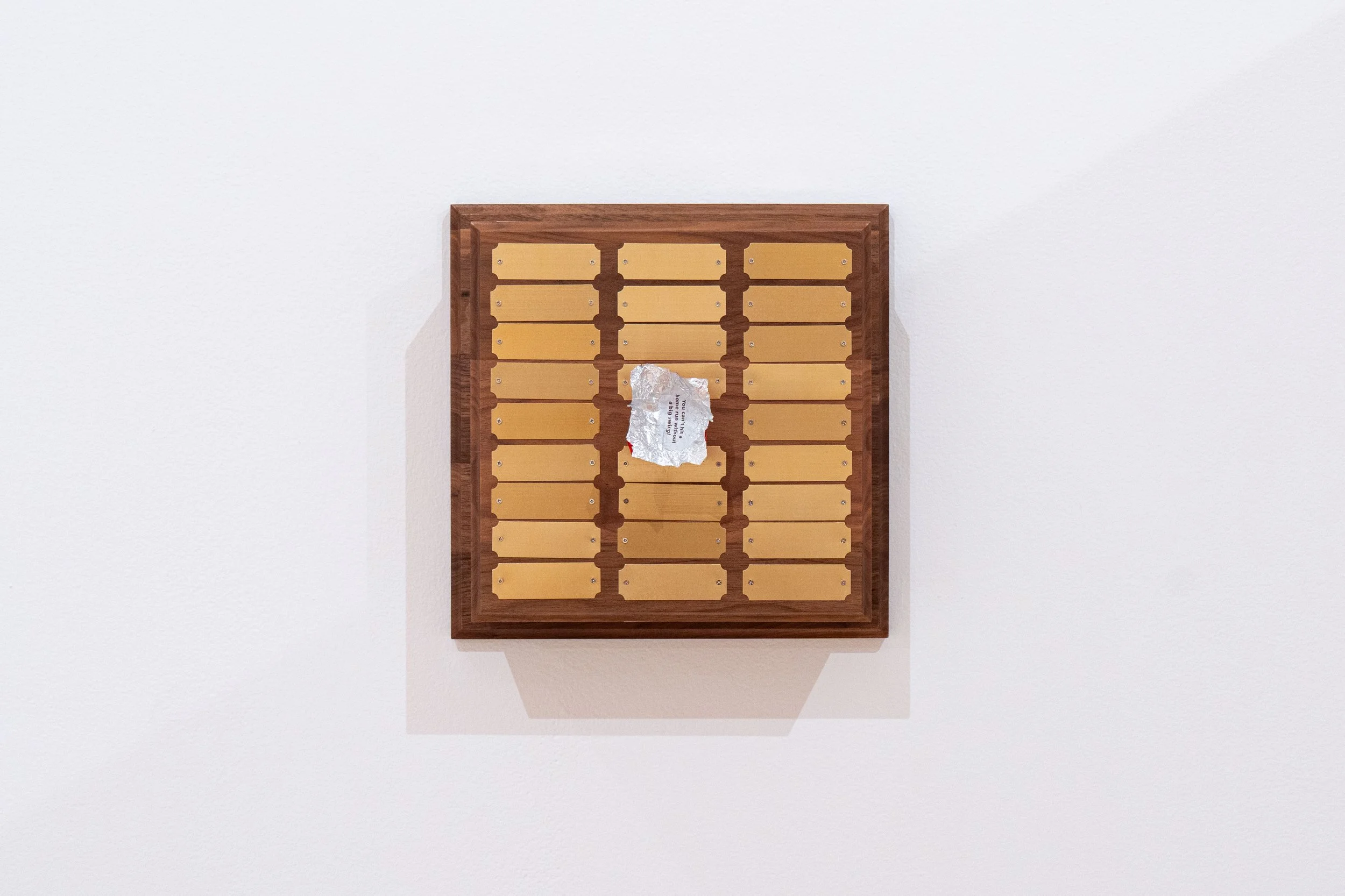   Untitled (Perpetual Plaque) —   Walnut, brass, clock movement, foil chocolate wrapper
 
Image courtesy of Priya Vaswani