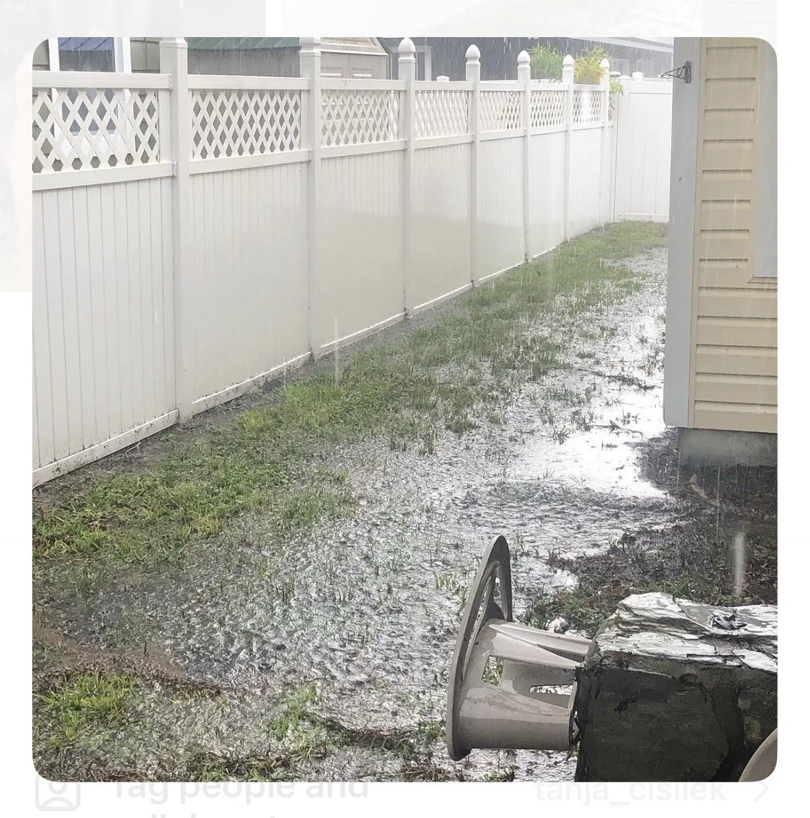 Standing water beside a Tampa Bay home during heavy summer rain, illustrating the importance of gutter drainage and directing roof runoff away from the house.