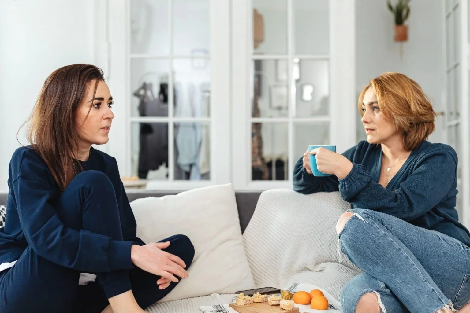 Two women sitting together in conversation at home
