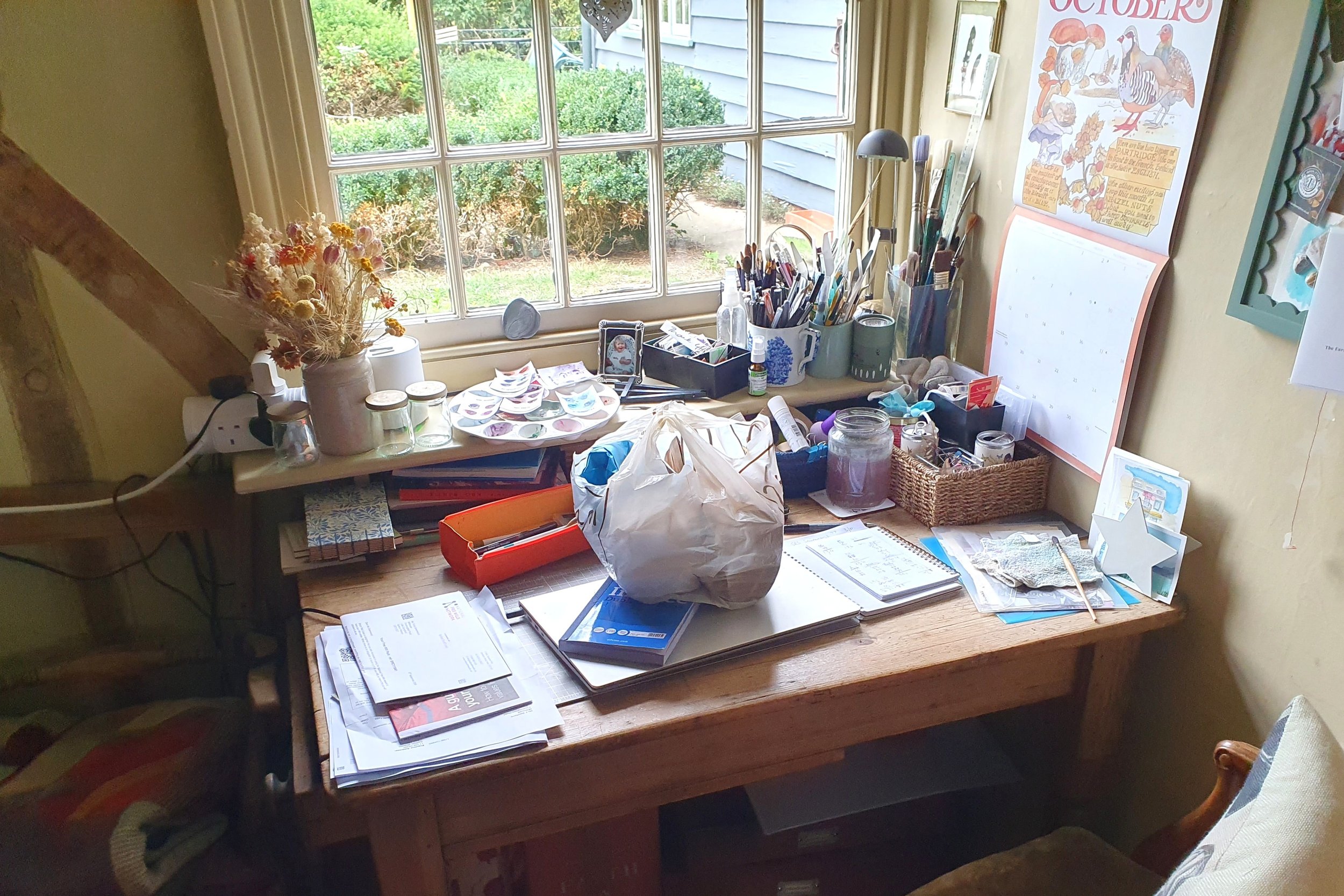 Craft table covered with papers, tools and materials before a Willow & Home organising session.