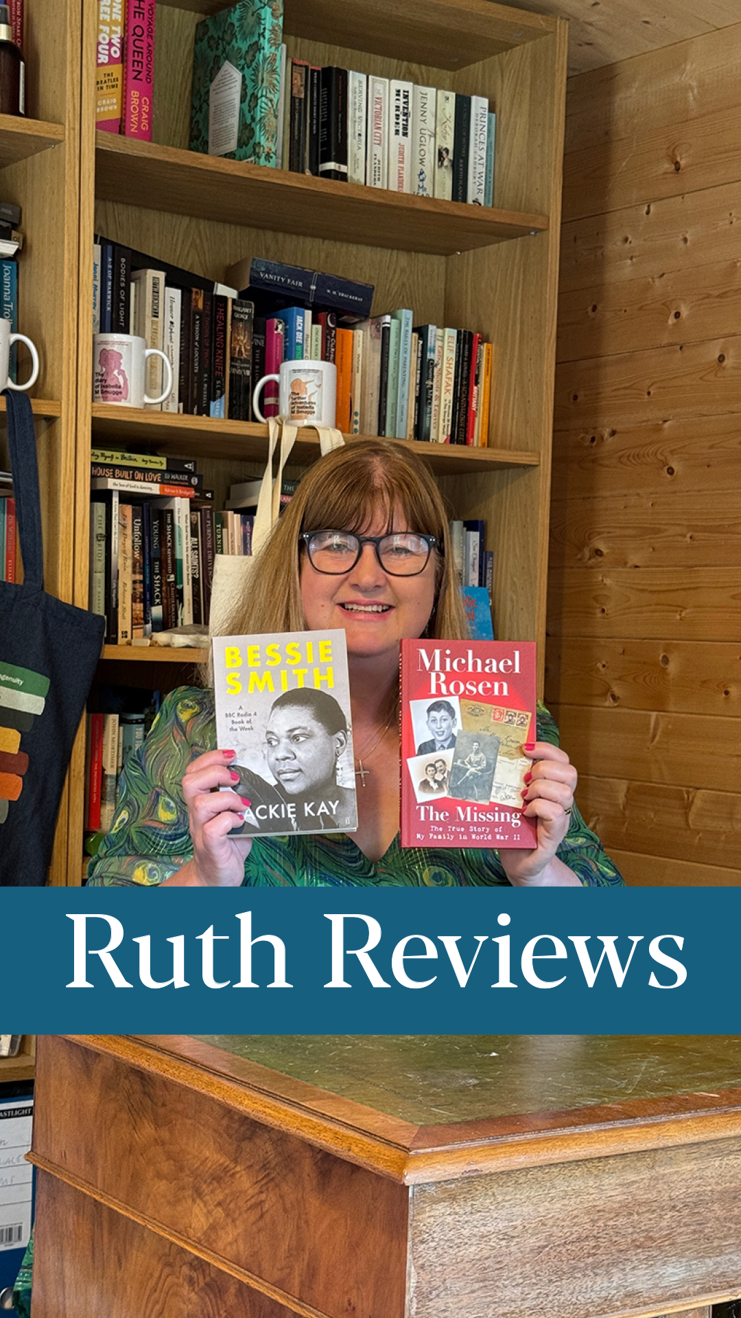 A woman with glasses and shoulder-length hair smiling while holding two books, one titled 'Bessie Smith' by Jackie Kay and the other 'Michael Rosen The Missing.' She is standing in front of a wooden bookshelf filled with various books and mugs, with a blue banner at the bottom that reads 'Ruth Reviews.'