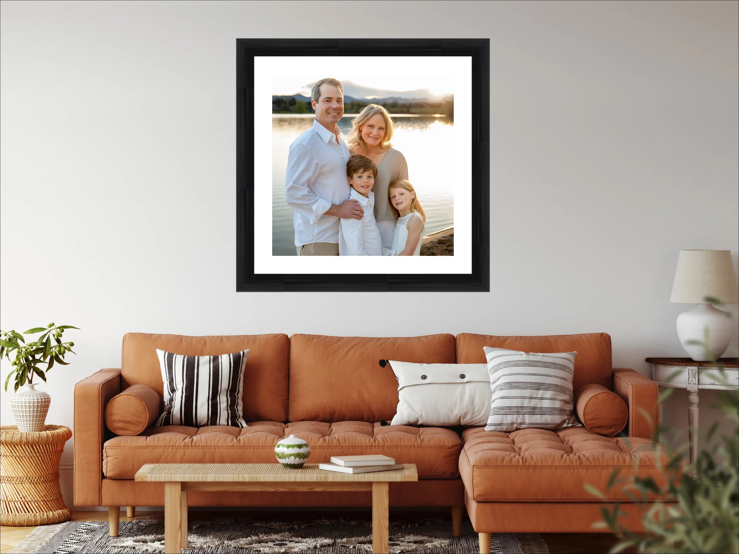 Living room with beige sofa, brown pillows, and wall art featuring three baby photographs above the couch