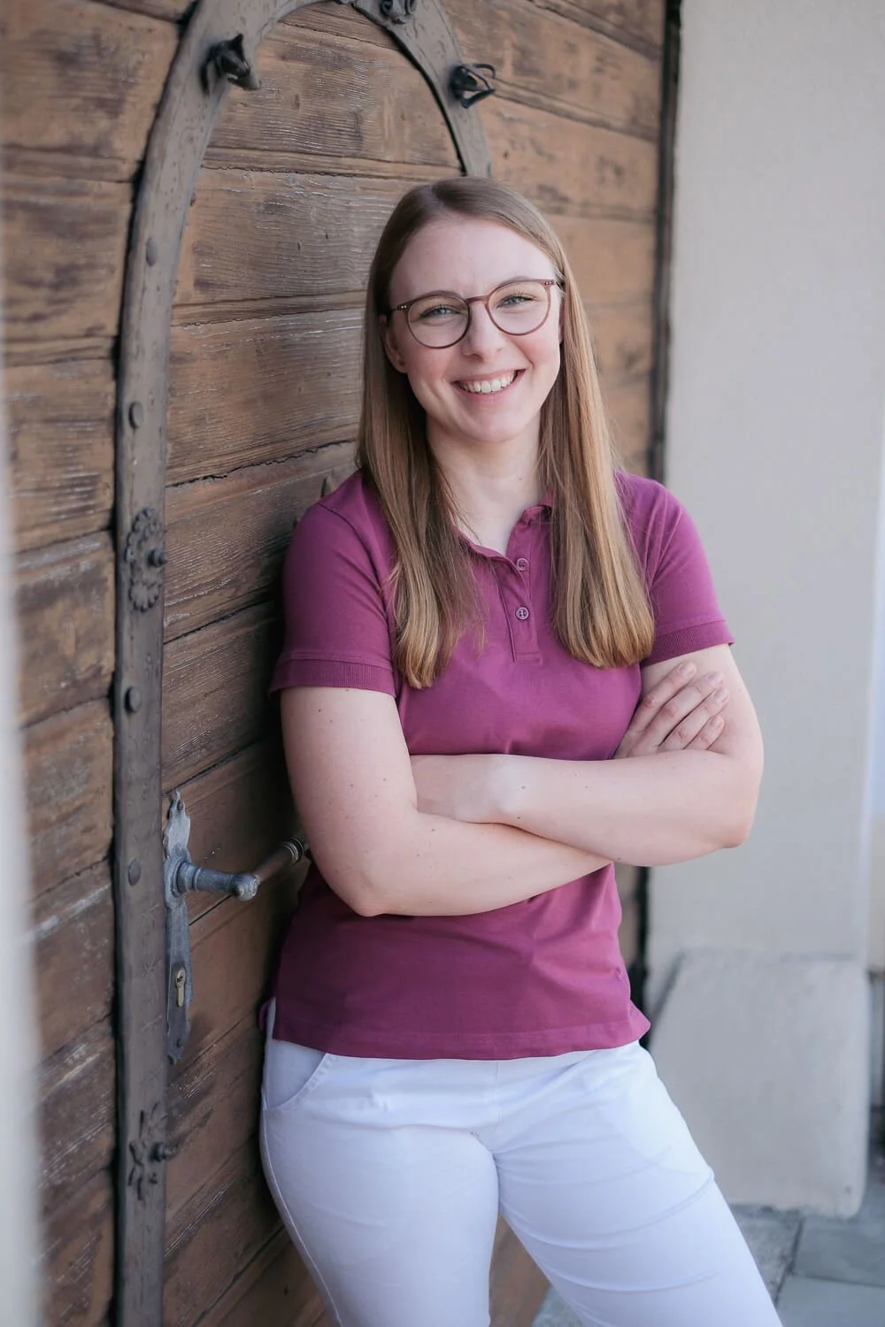 Portrait von Physiotherapeutin Julia Schmoll vor ihrer Praxis in Ebreichsdorf