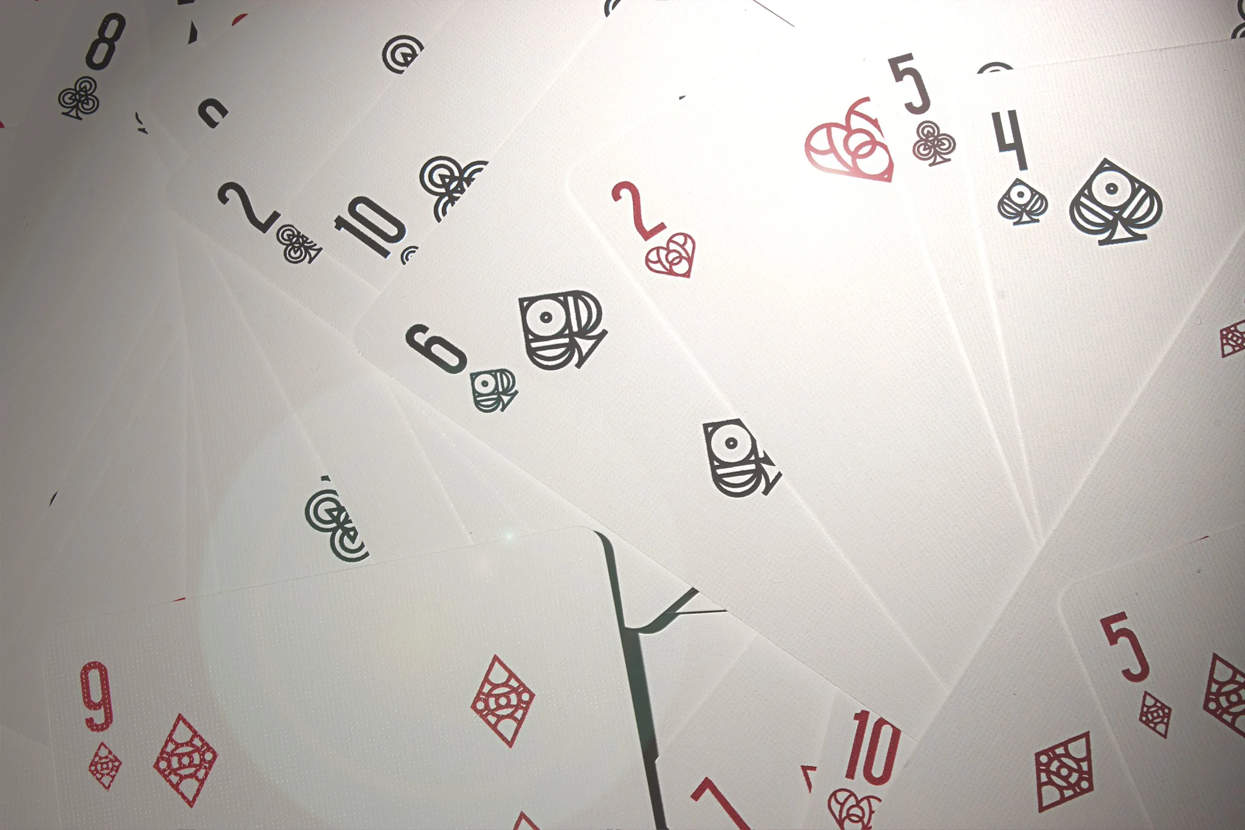 A spread of playing cards showing the 2, 3, 4, 5, 6, 7, 8, 9, 10, Jack, Queen, King, and Ace of spades, with some cards overlapping.