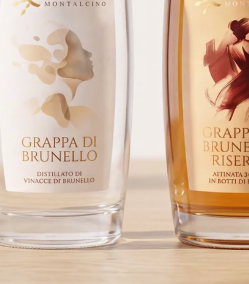 Close-up of two bottles of Montalcino grappa di Brunello, one clear and one amber, with labels visible.