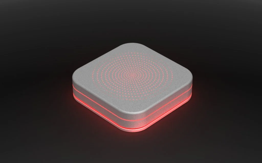 A modern, square-shaped electronic device with a textured gray top surface and red LED lights along the edges, placed on a black background.
