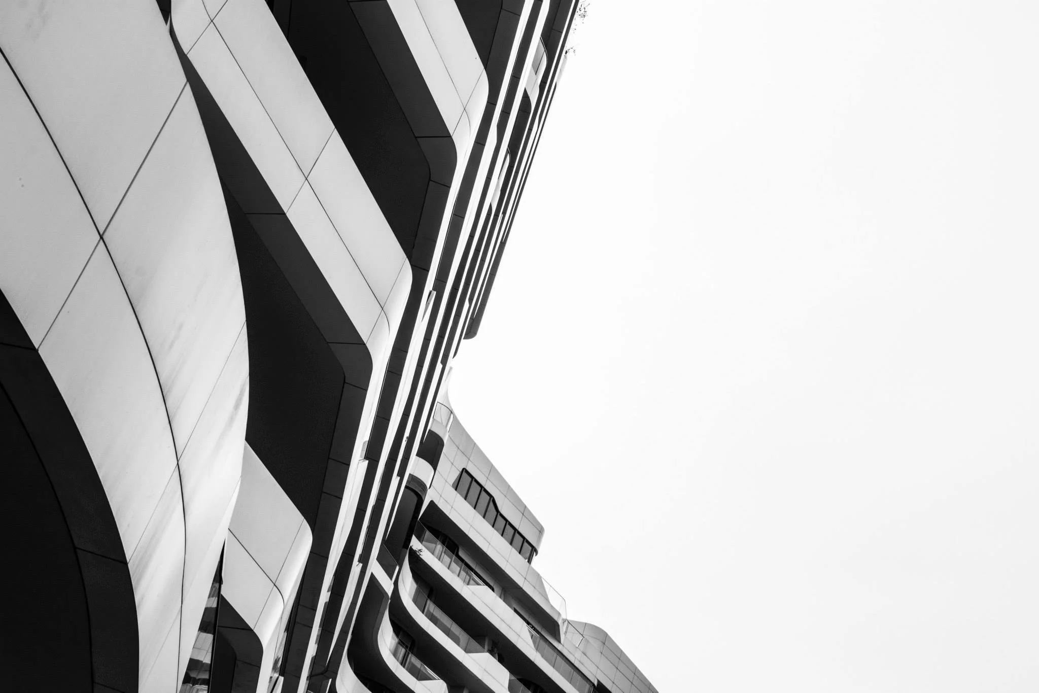 Black and white photo of a contemporary building with curved architectural design.