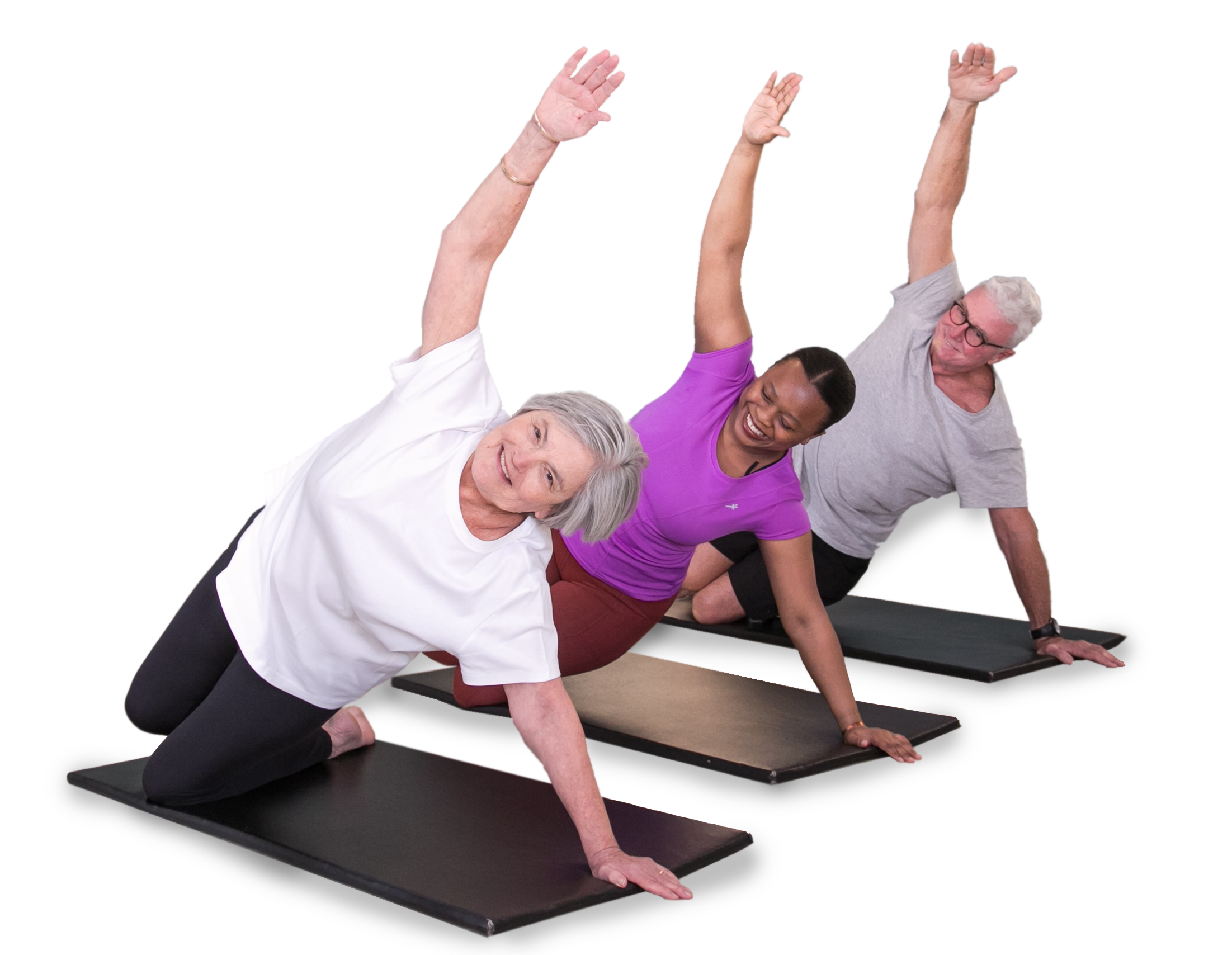 Three older adults and one younger adult practicing yoga on black mats, in a side plank pose, in a fitness studio with light-colored walls.