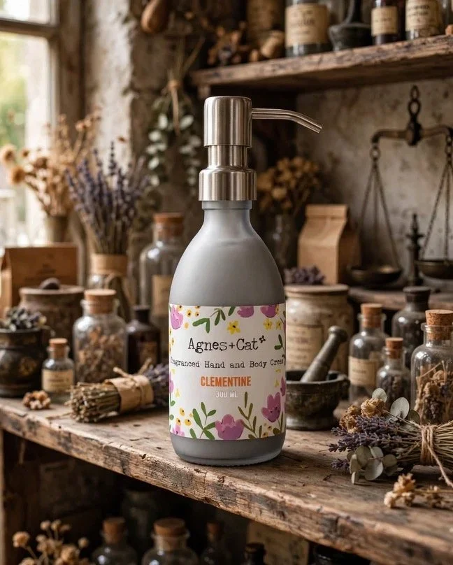 Agnes + Cat Clementine hand and body cream pump bottle on a rustic shelf