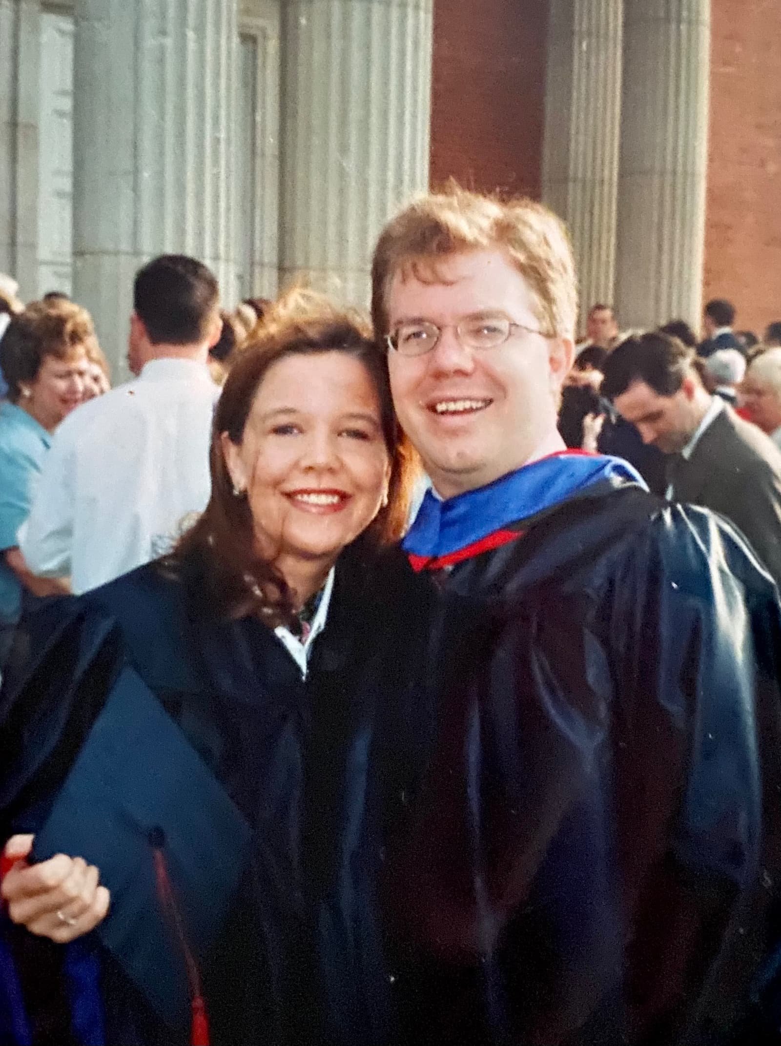 Kristie and Keith Sullivan taking a selfie together on Keith's graduation day, with other attendees in the background.