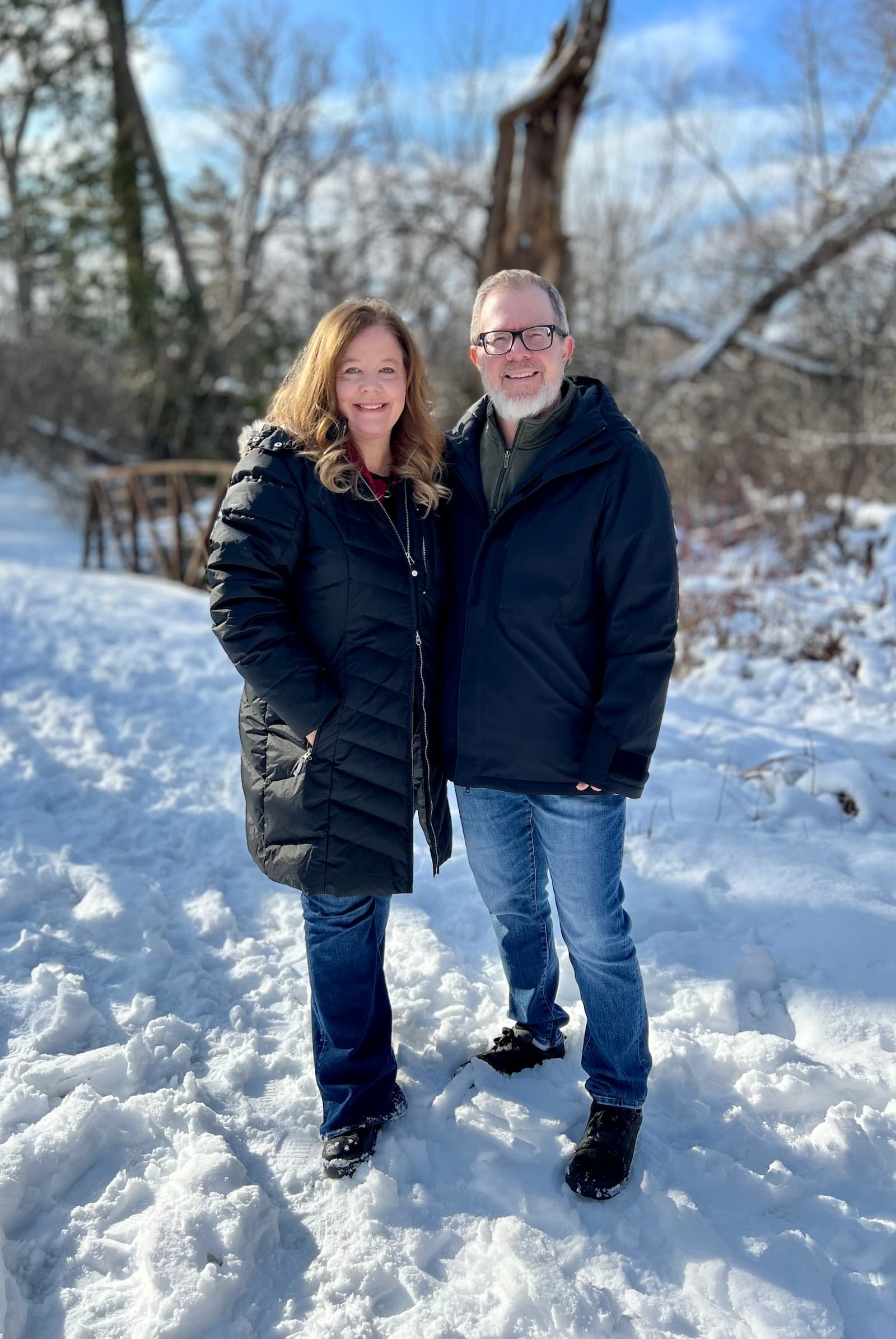 Kristie and Keith Sullivan standing outdoors in the snow in Canada, wearing winter coats.