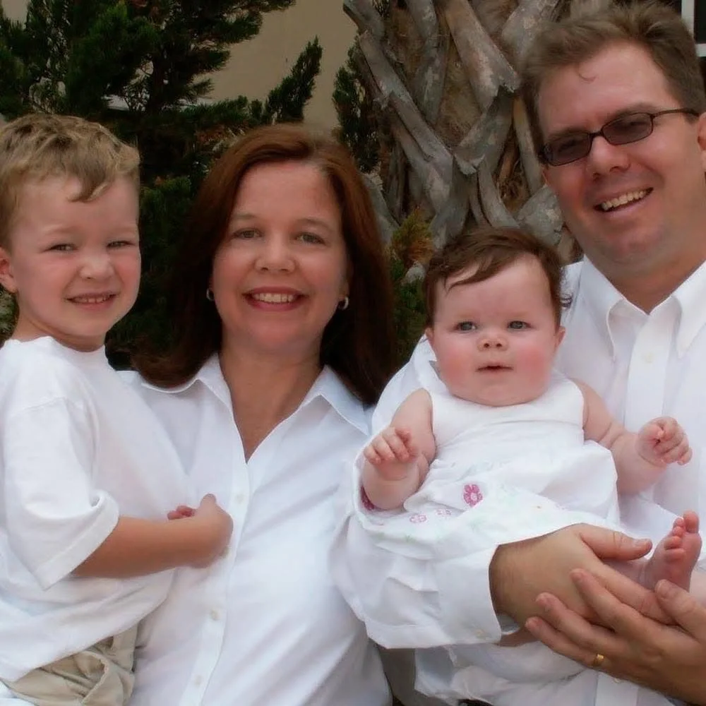 The Sullivan family at their missionary appointment service, four family members smiling outdoors near trees.