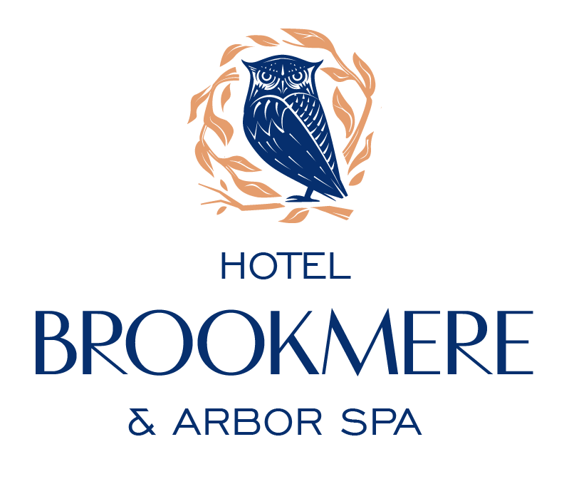 Hotel Brookmere & Arbor Spa logo in dark blue, with an owl surrounded by orange foliage