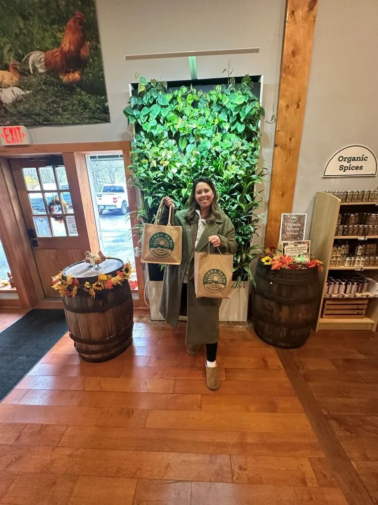 Michella holds two bags of purchased goods at Tierra Farms