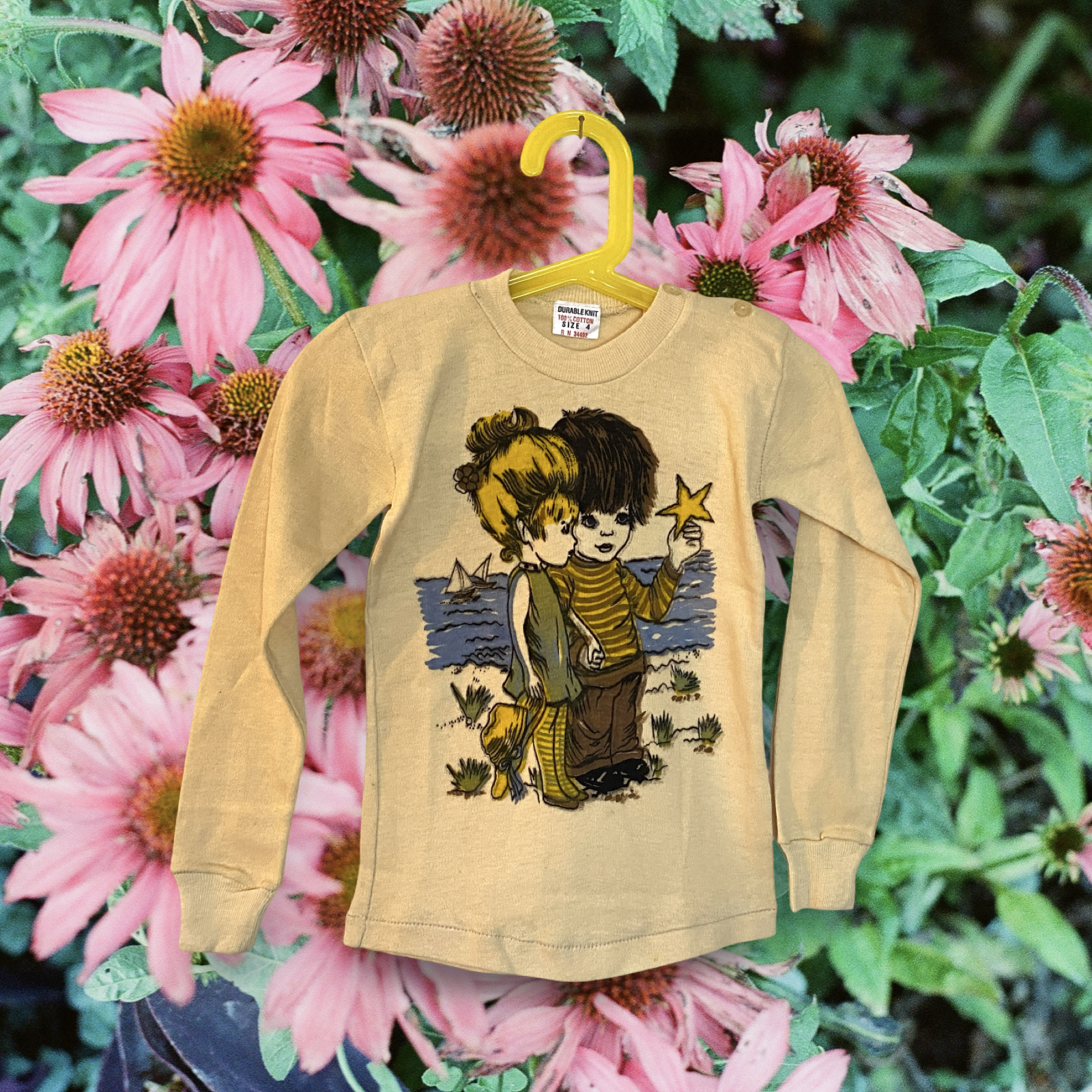 Vintage 1960s yellow sweatshirt with a graphic of two children walking by the sea, one girl and one boy, with pink flowers in the background.