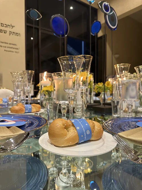 Centro de mesa con flores amarillas, velas y ojos de vidrio azul