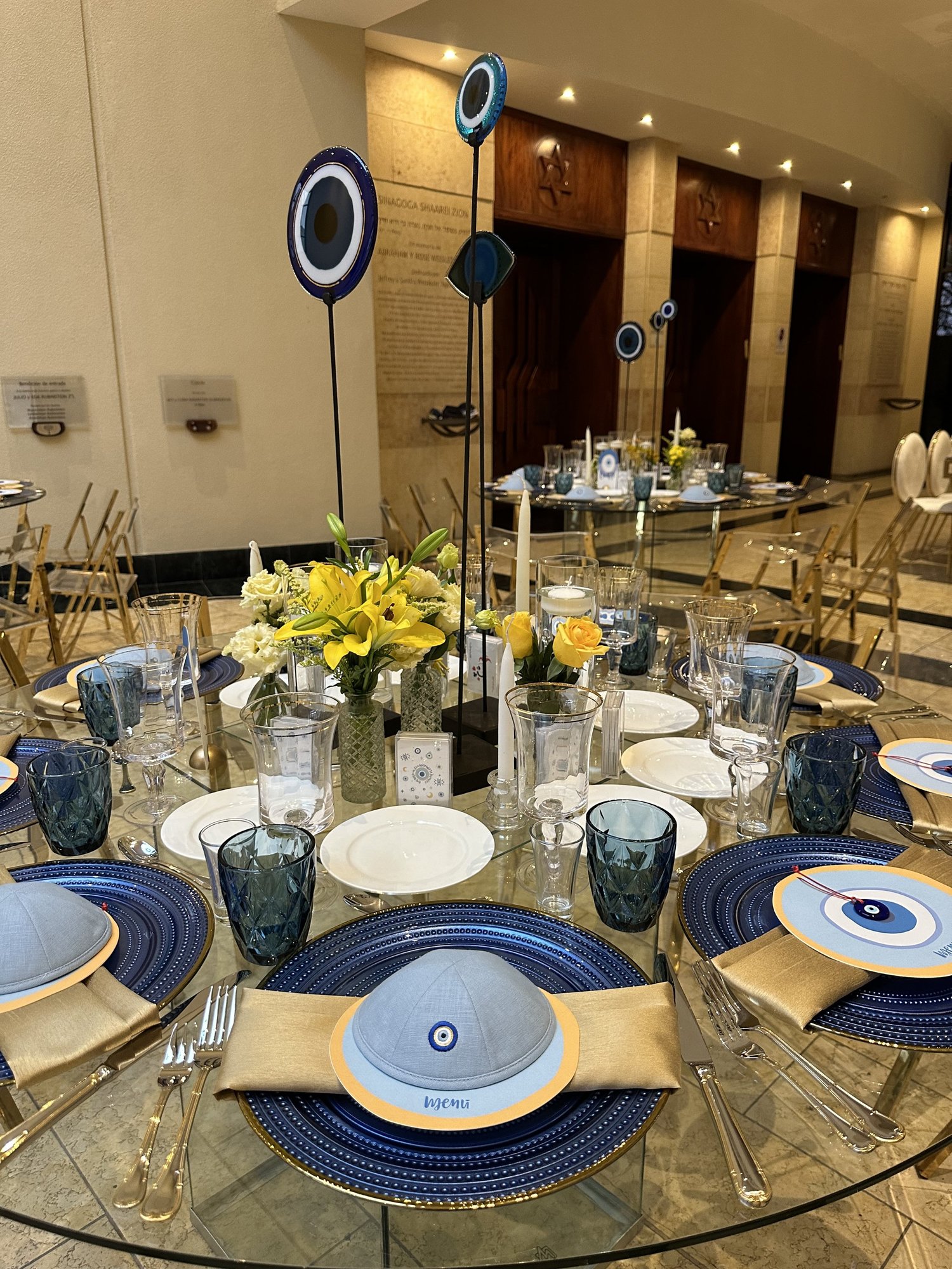 Mesa con vajilla azul y esculturas de ojos de vidrio