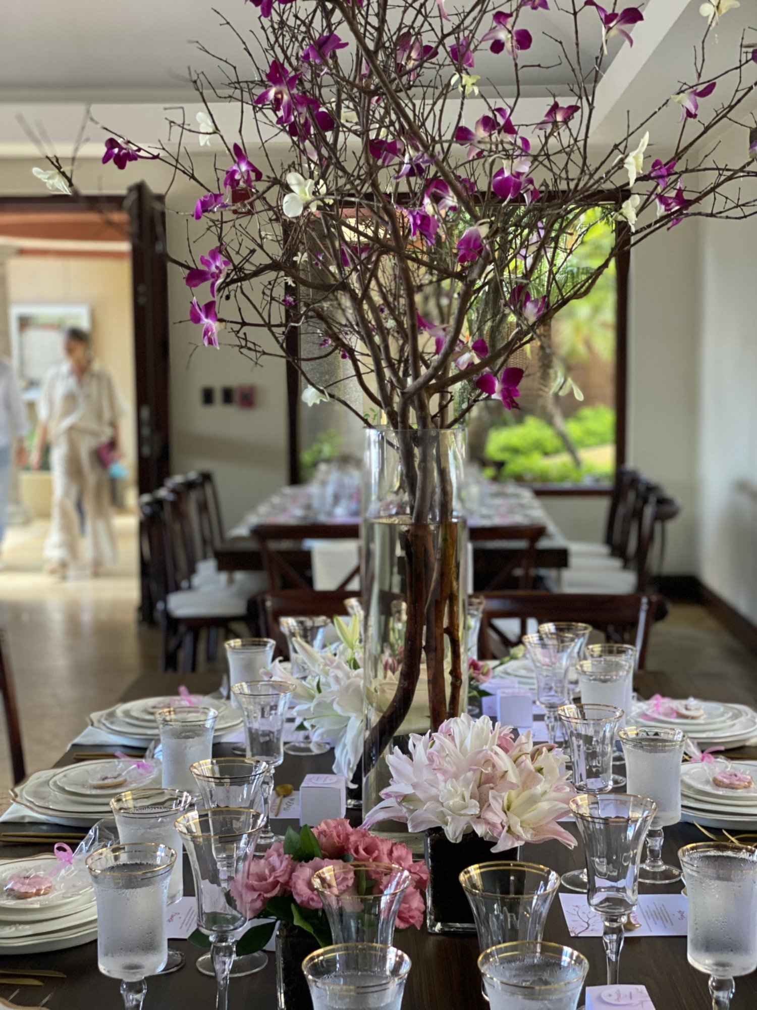 Mesas con copas y cerezos en flor en el salón