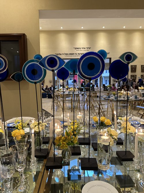 Esculturas de ojos turcos de vidrio soplado en azul, montadas a distintas alturas sobre la mesa