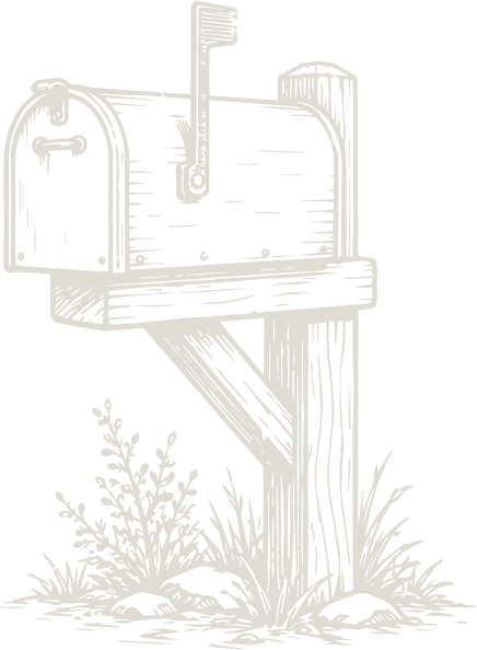 A vintage-style black mailbox mounted on a wooden post with grass at the base.