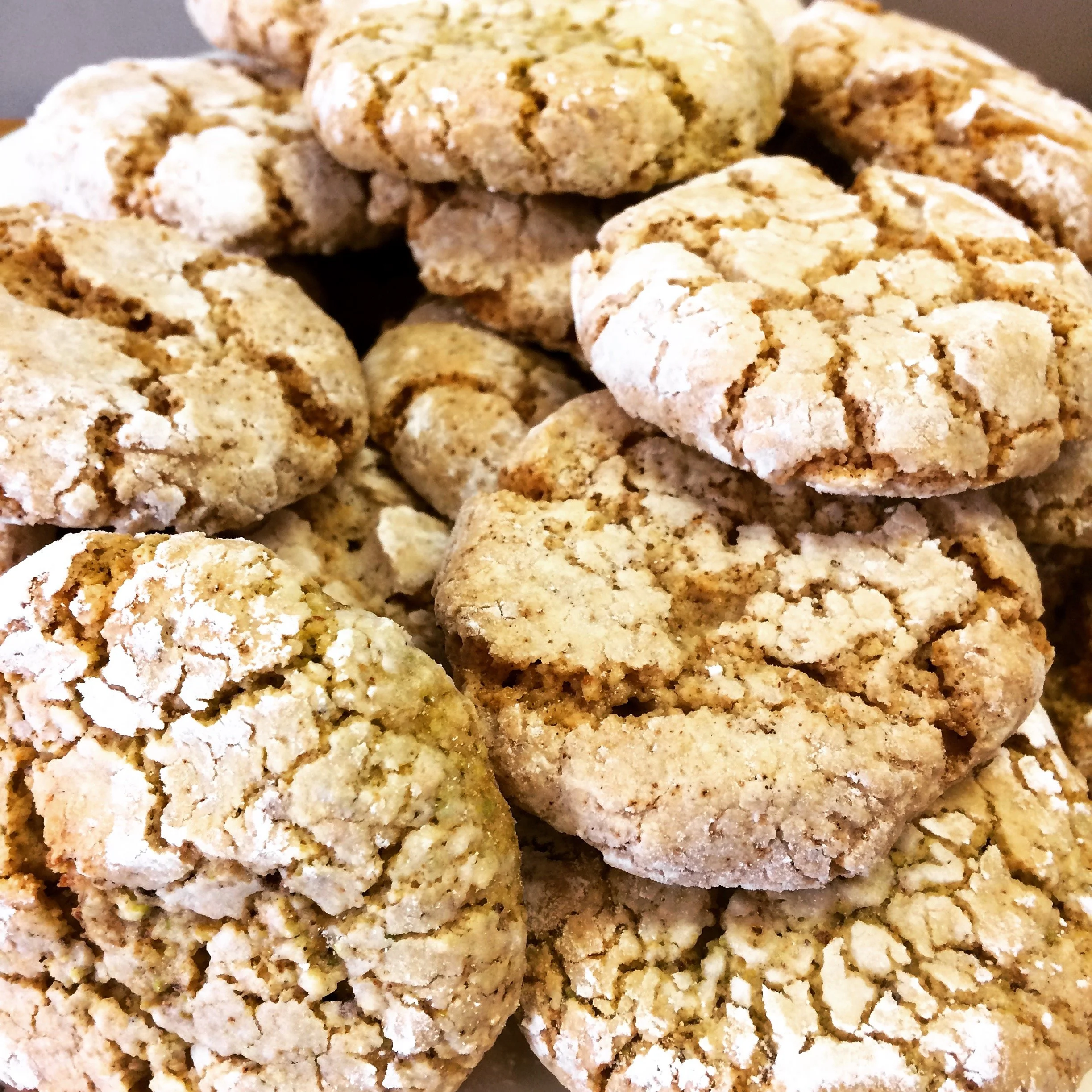 Close-up of multiple oatmeal cookies stacked together, showing their cracked and crumbly surface.