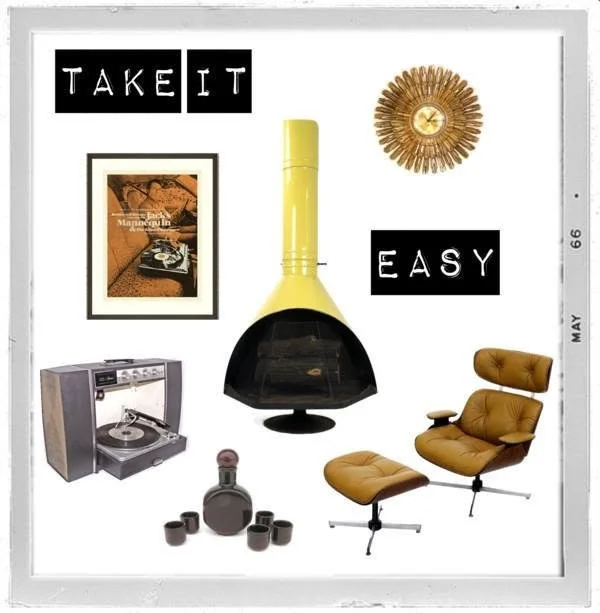 Decorative wall with black signs reading "Take It" and "Easy," vintage record player, modern yellow fireplace, framed magazine cover, brown lounge chair with ottoman, black decanter and glasses, golden clock with sunburst design.