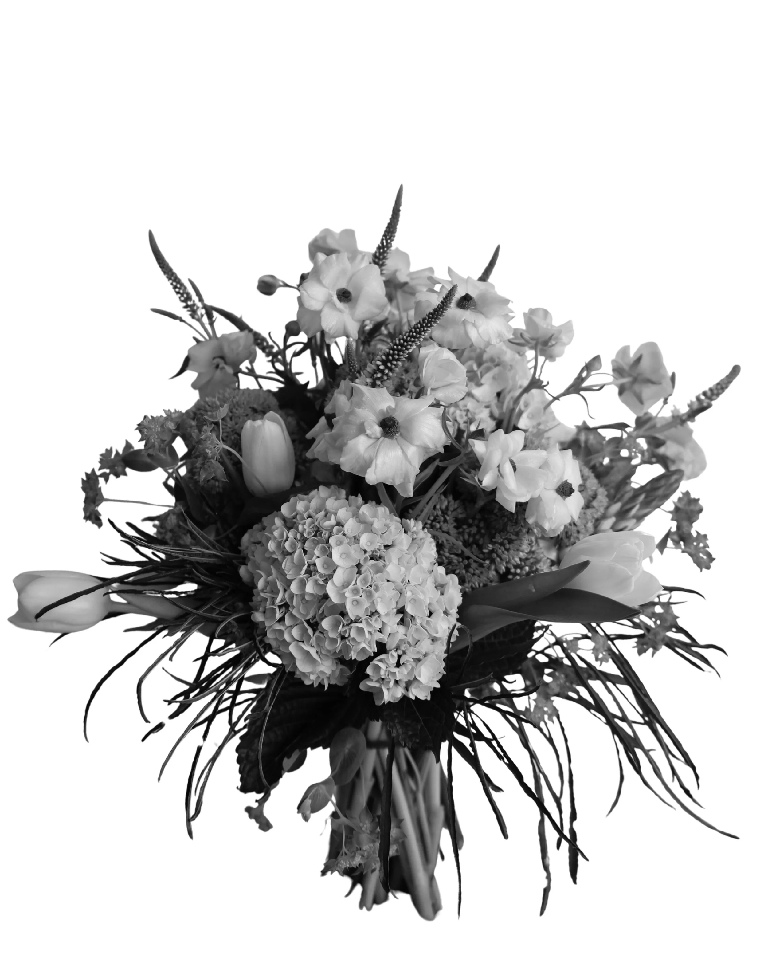 Black and white photo of a floral bouquet with various flowers and foliage.