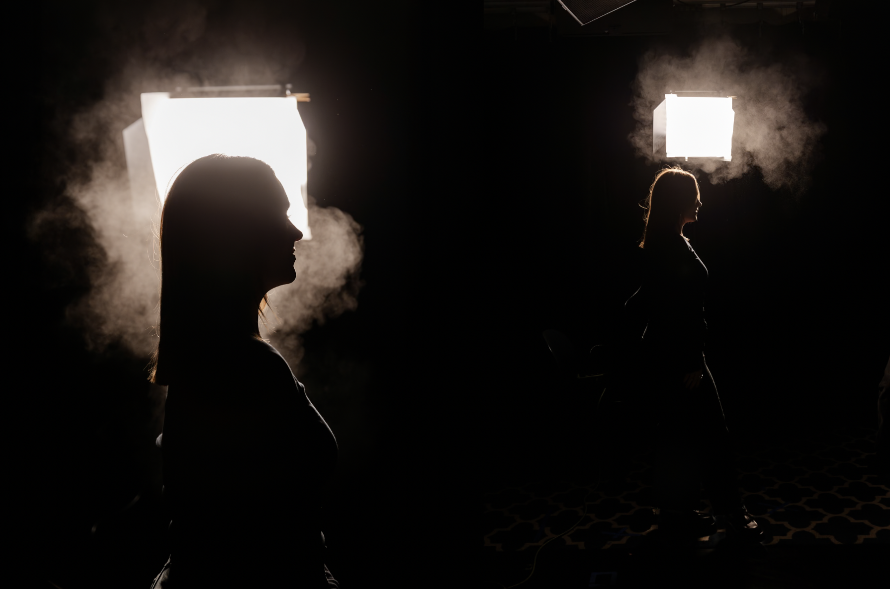 Silhouetted woman in a dark photo studio with bright softbox lights and atmospheric smoke