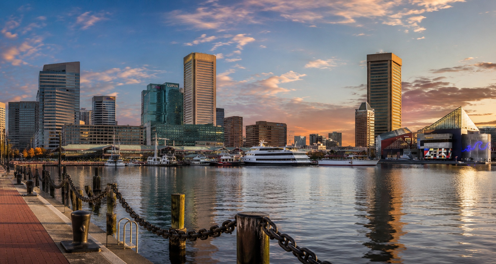 City skyline during sunset over a harbor with boats and tall buildings.