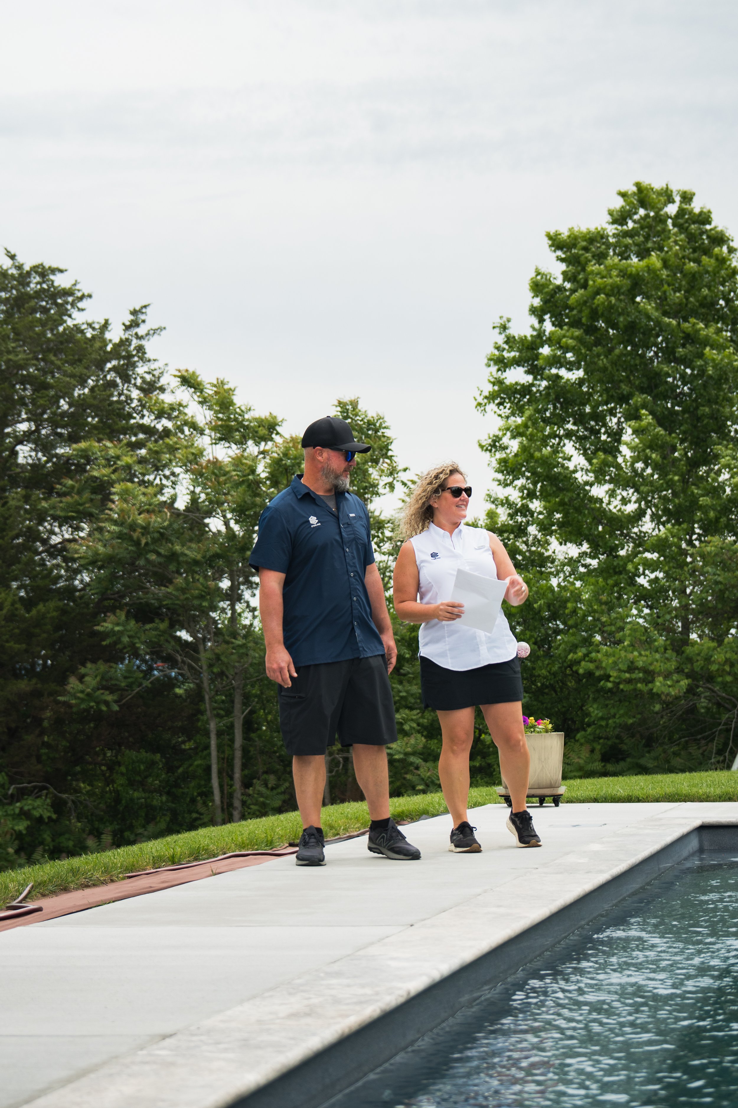 Ben and Steph, owners of Sterling Pools, standing beside a finished gunite pool in Middle Tennessee