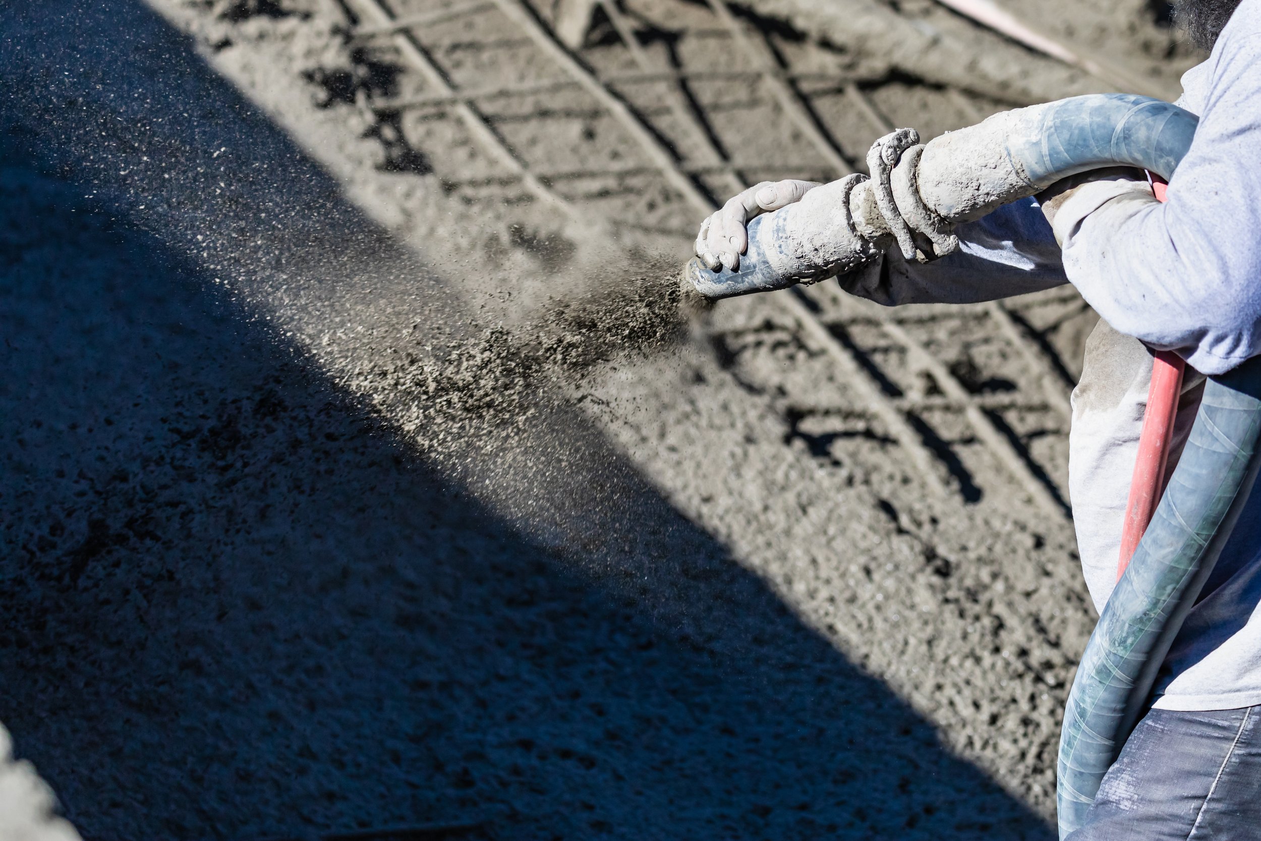 Gunite pool construction, crew spraying concrete shell into an in-ground pool excavation