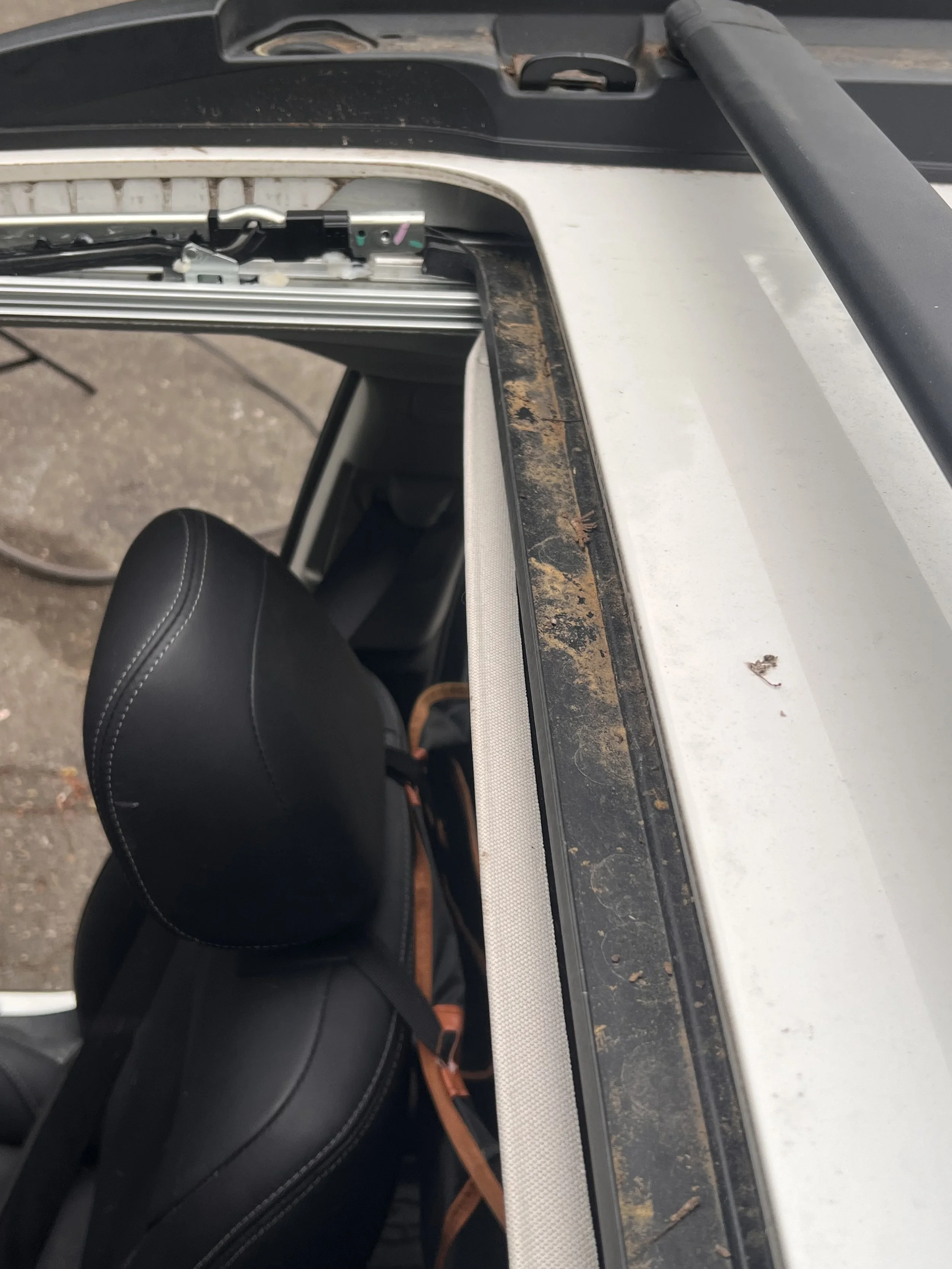 Access — Sunroof track and cassette components exposed during diagnosis.
