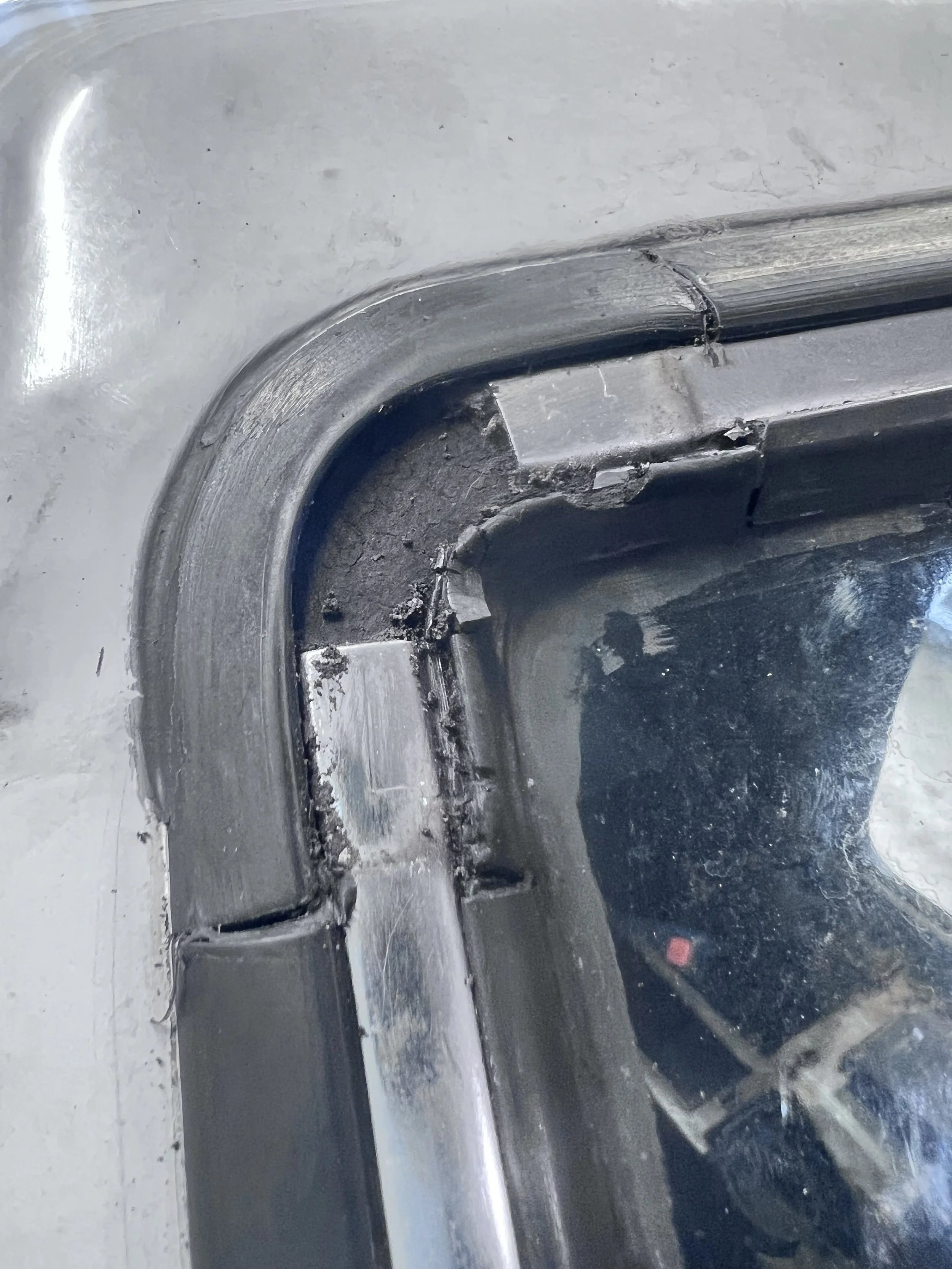 Seal detail — Cracked and separated weatherstrip seam documented at the glass opening.