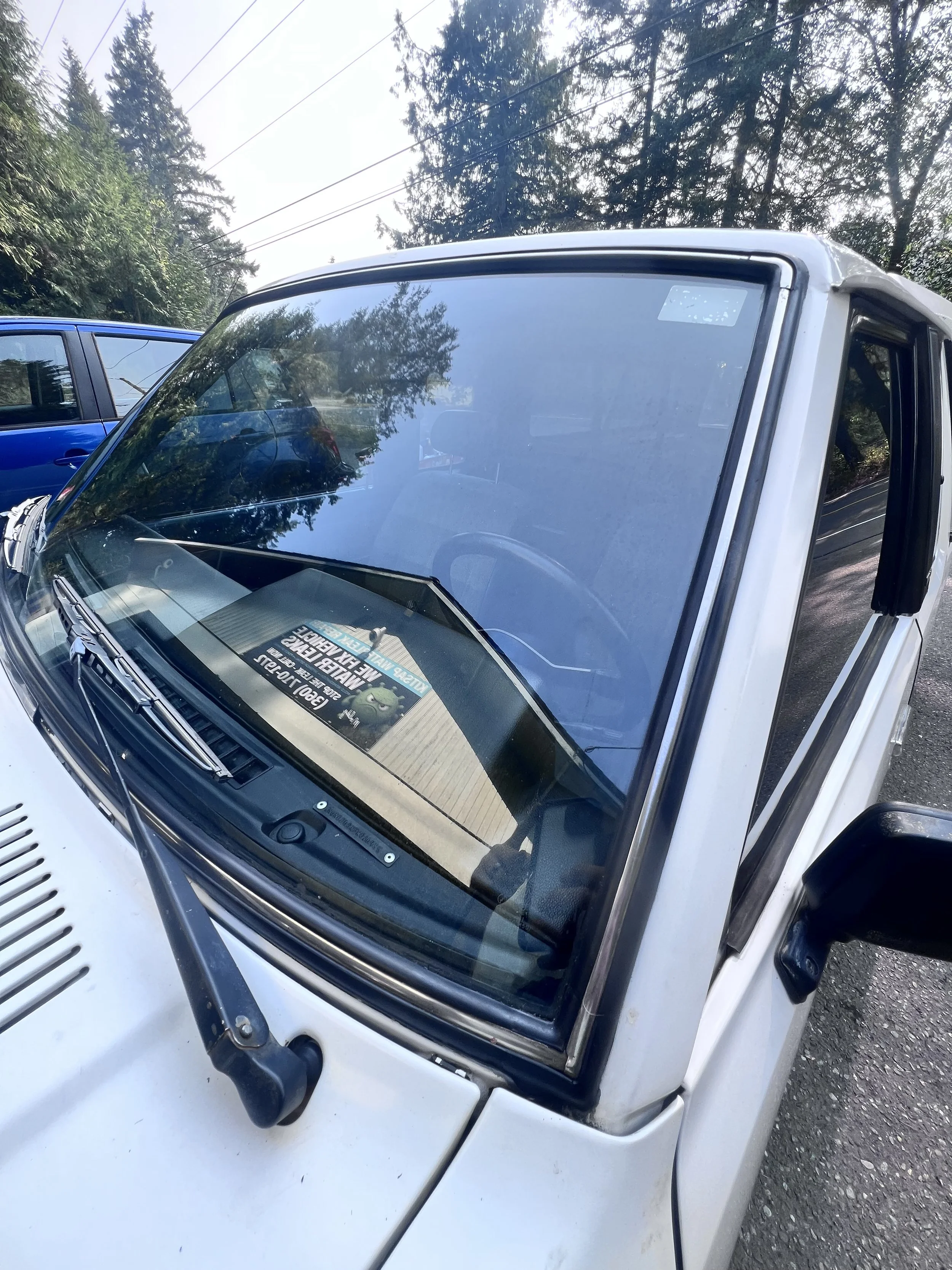 Front-glass inspection — Windshield perimeter and weatherstrip fitment checked on the classic Nissan.