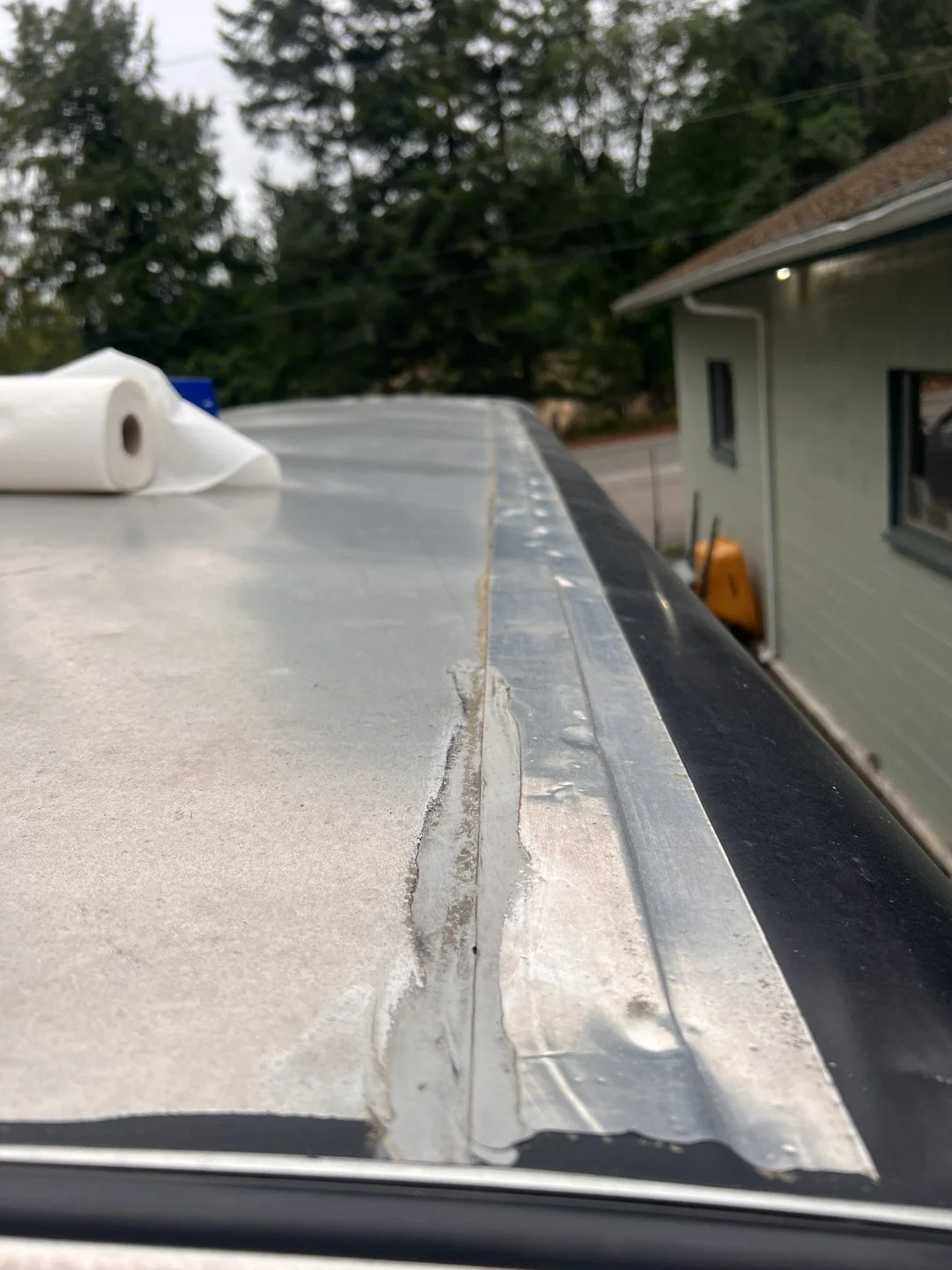 Classic glass and weatherstrip — Deteriorated seal and adhesive documented at the glass edge.